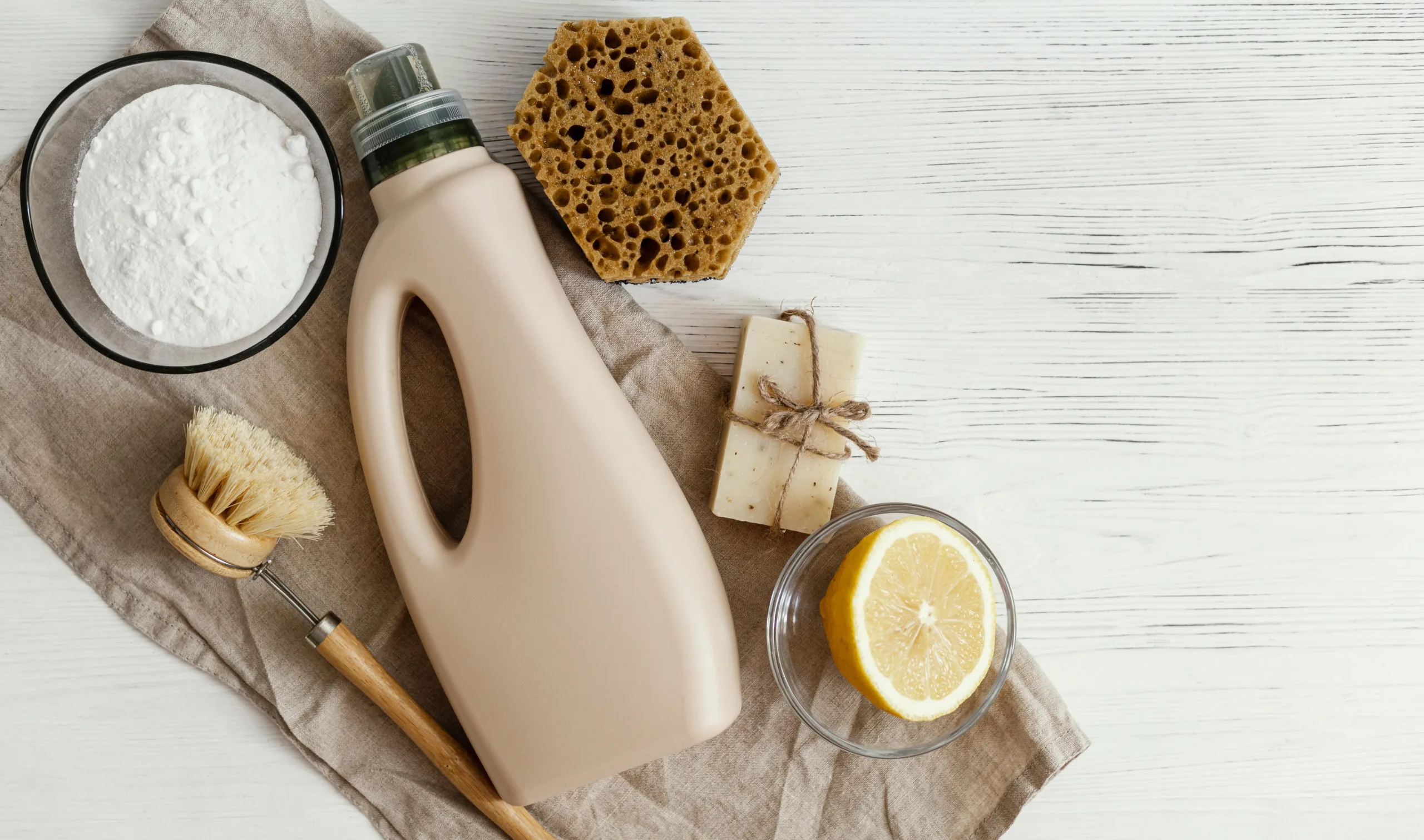 Benefits of natural cleaning solutions with baking soda, vinegar, lemon, and glass bottles