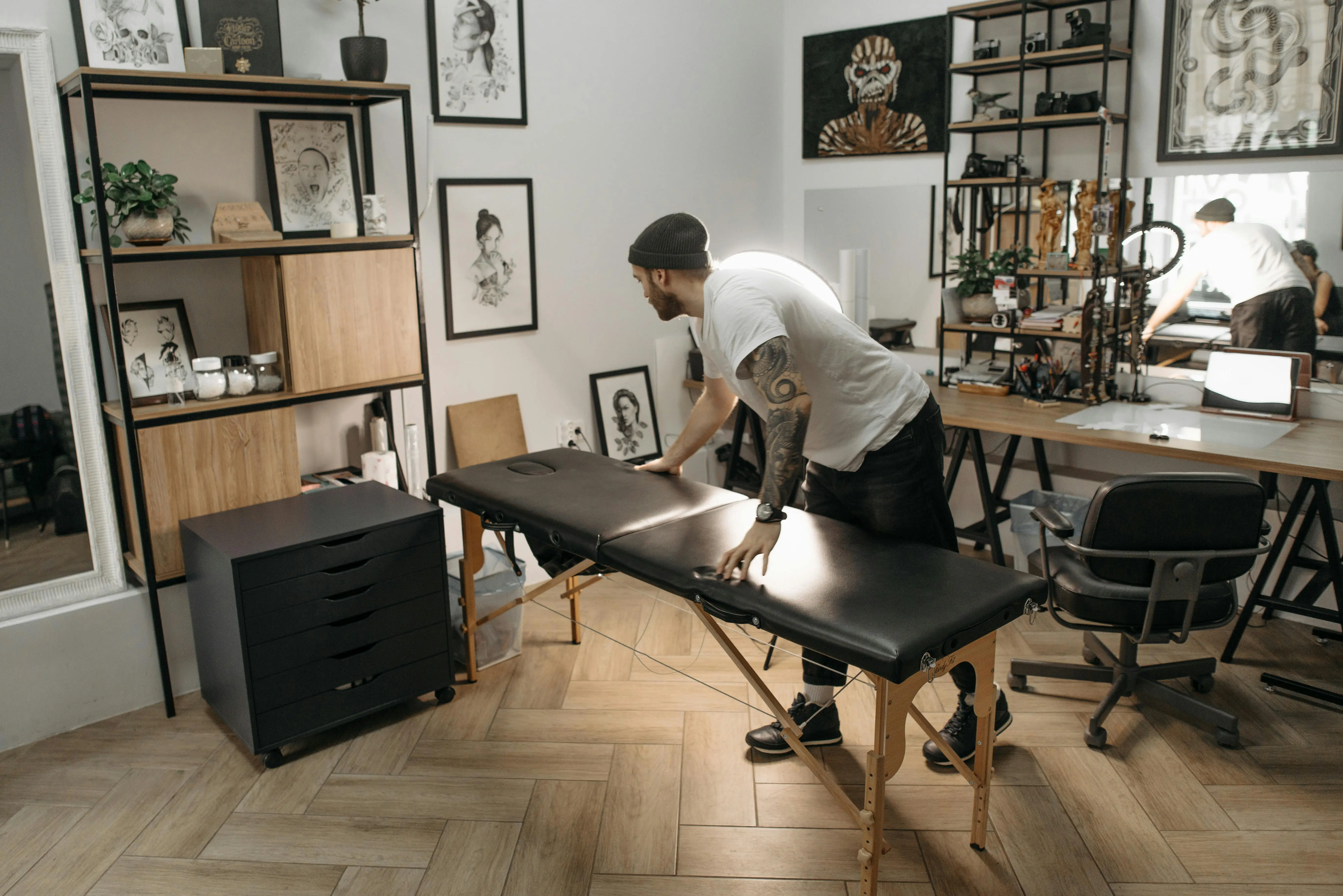 full size bed with storage Tattoo artist arranging work table in a stylish studio with art decor and cozy setup.
