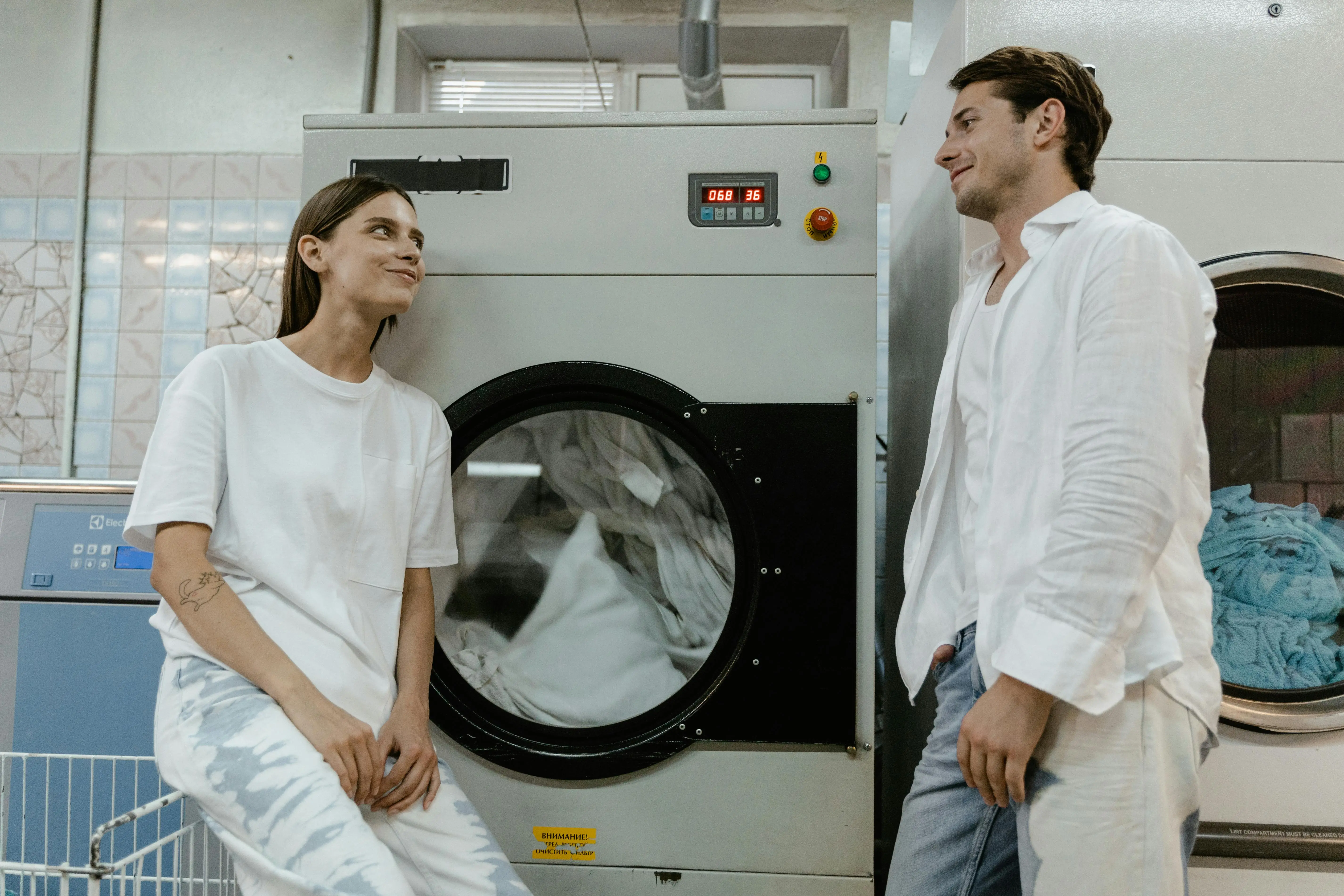 homemade laundry detergent A man and woman casually chatting in a contemporary laundromat setting.