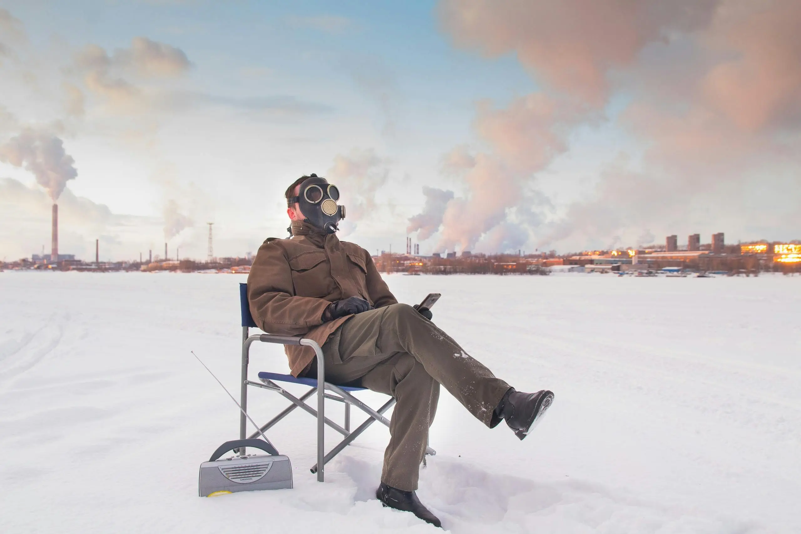 what might protect your shirt from a grease stain A man in a gas mask sits outdoors in a snowy industrial area with visible pollution.