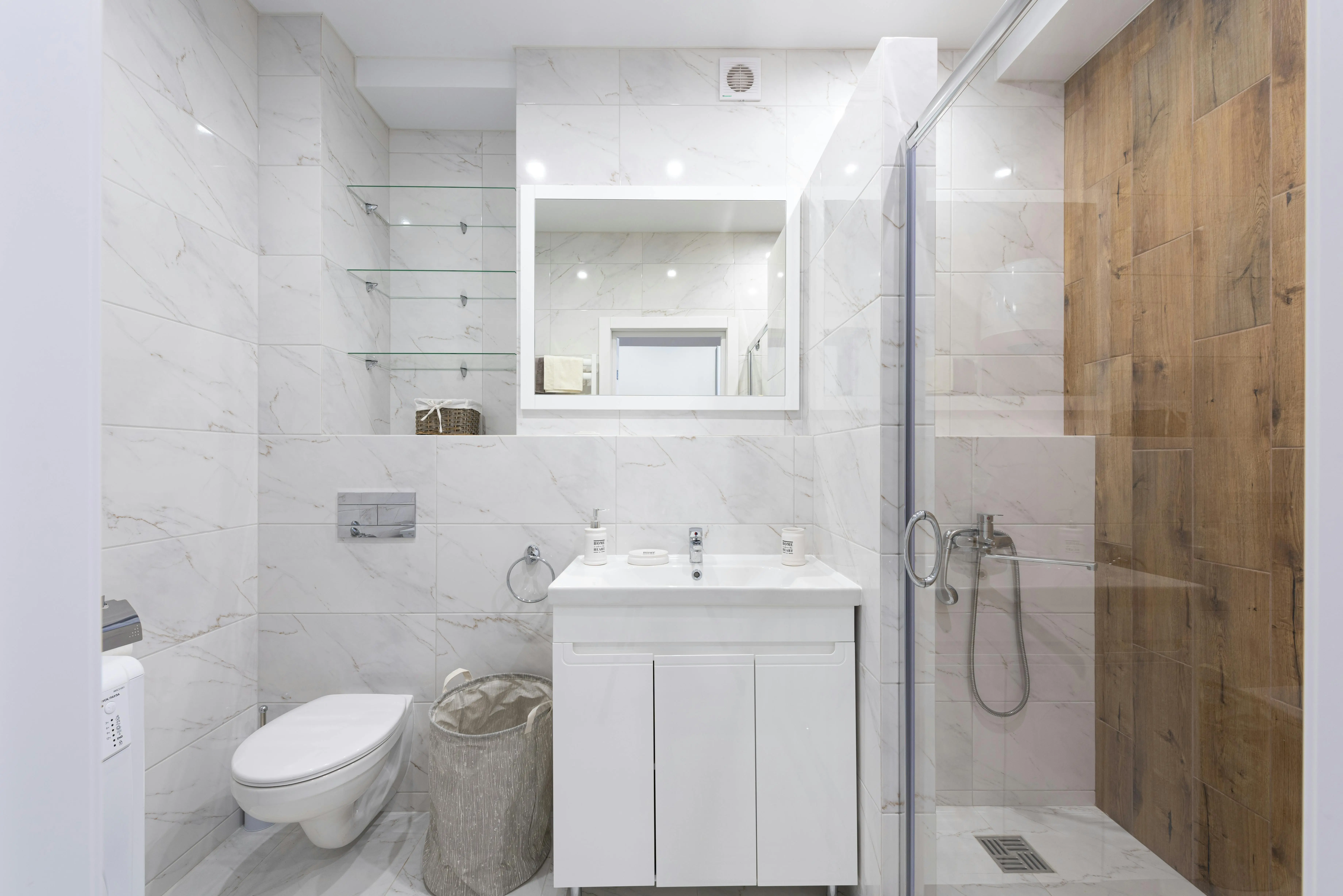 shower shelf Spacious minimalist bathroom with marble tiles and glass shower enclosure.