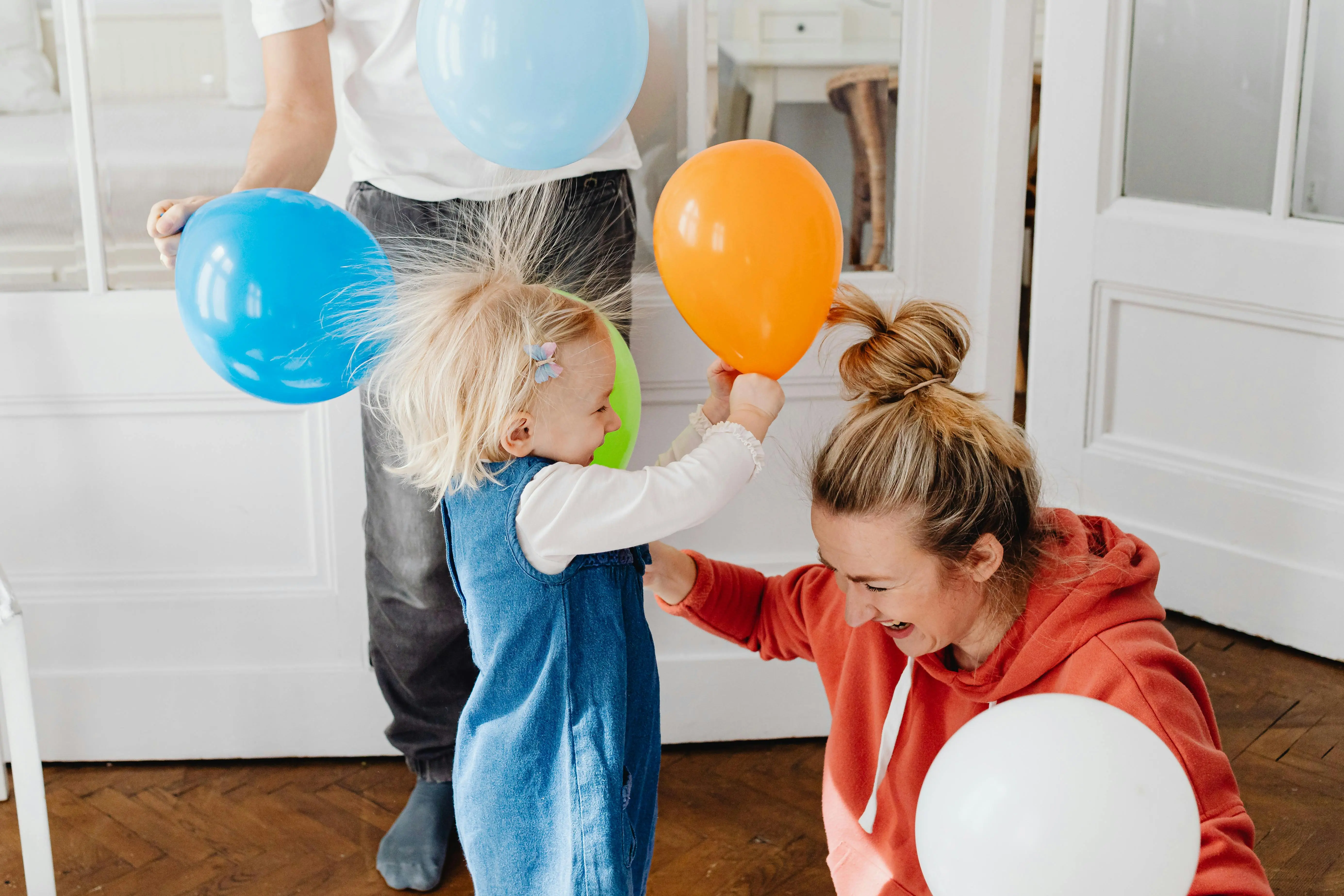 how to get rid of static on clothes A child and mother enjoying playful moments with colorful balloons indoors.