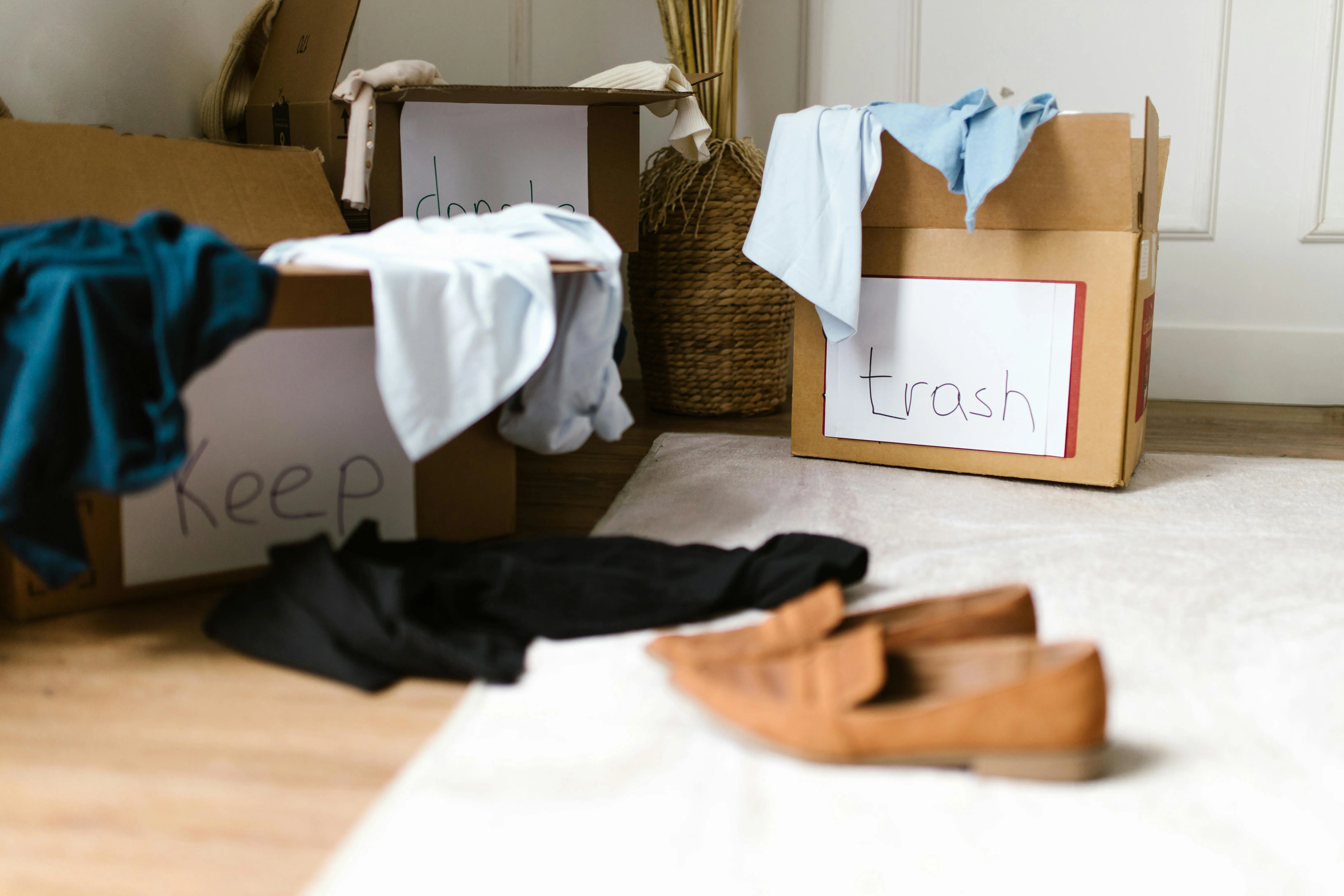 how to get mildew smell out of clothes Decluttering concept using labeled boxes for sorting clothes in a home setting.