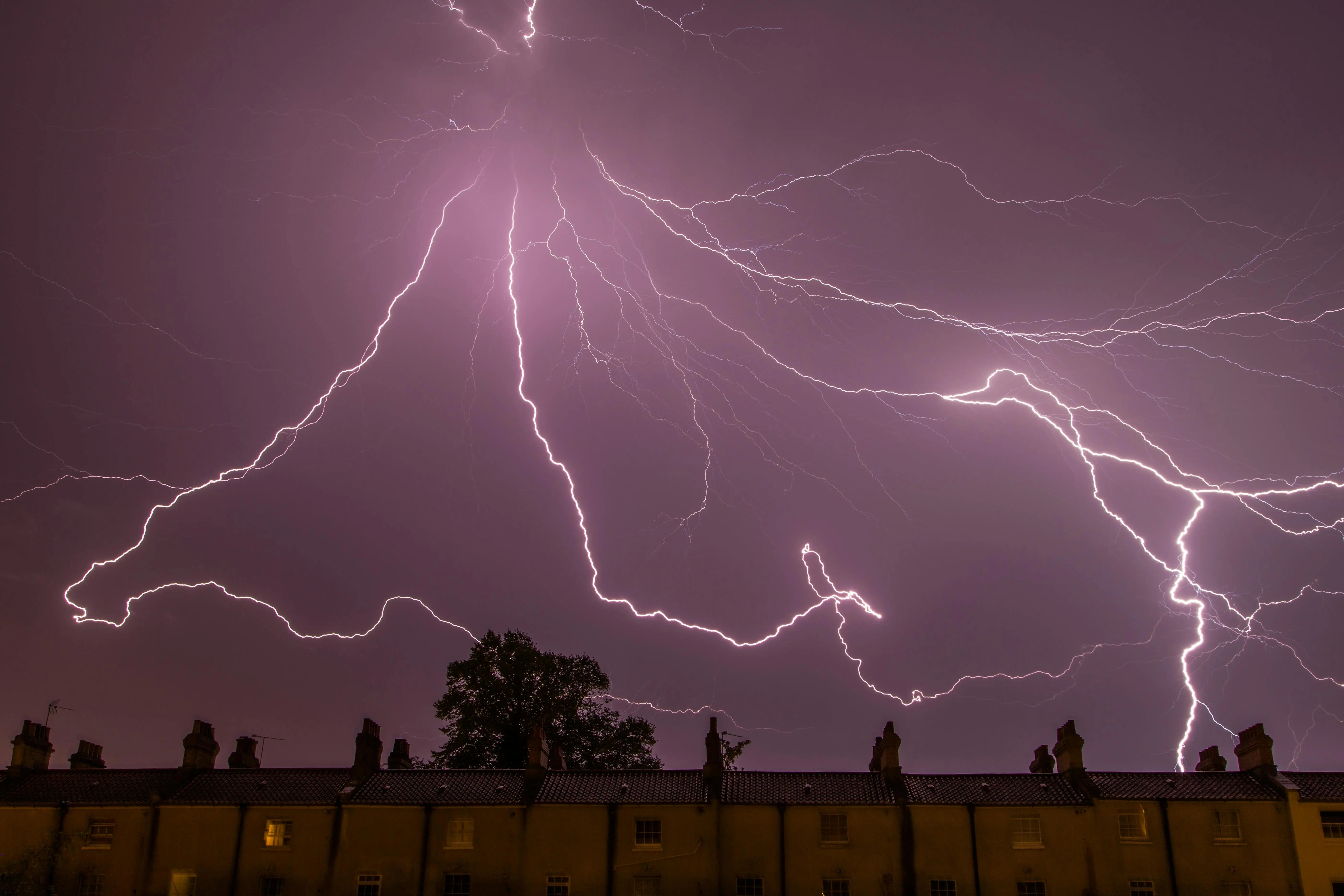 how to fix static electricity on clothes A captivating lightning storm illuminating the night sky above city rooftops.