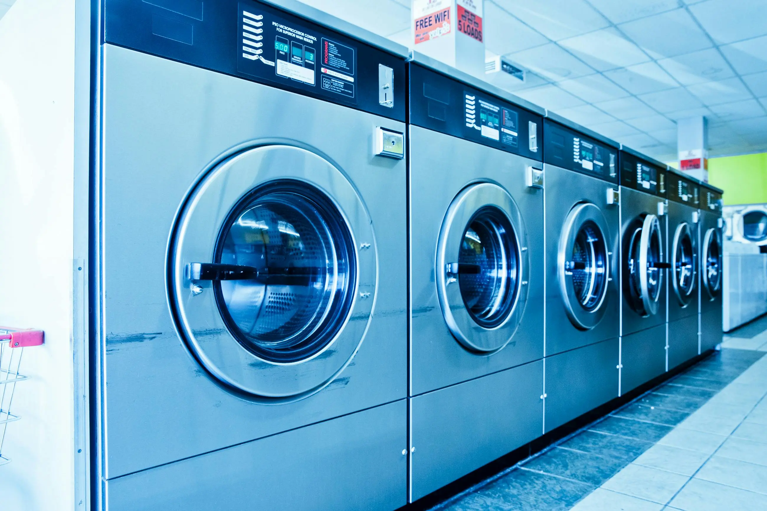commercial washing machine Interior of a contemporary launderette featuring advanced stainless steel washing machines.