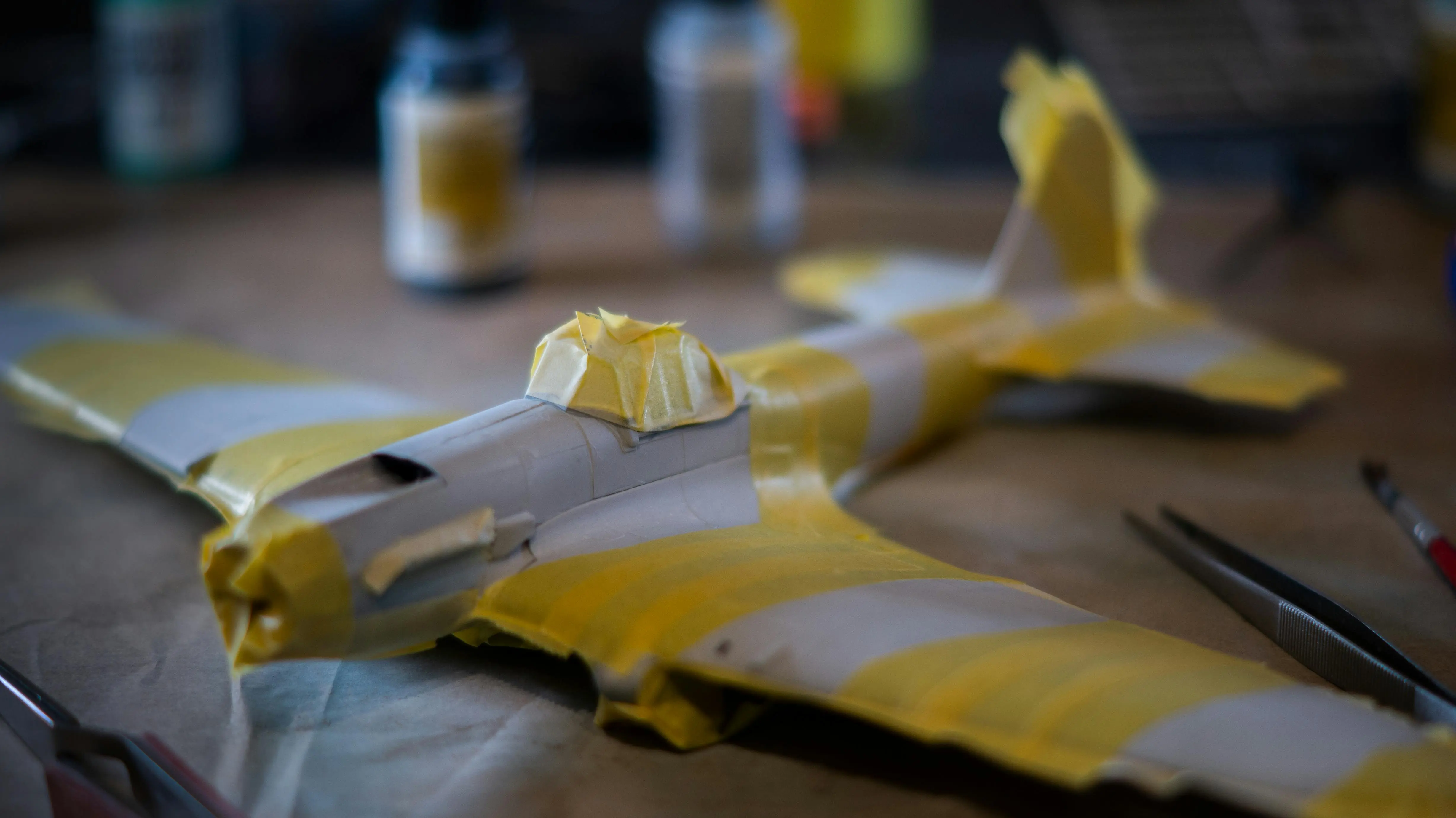 spring crafts Close-up of a plastic model airplane with masking tape on a crafting table.