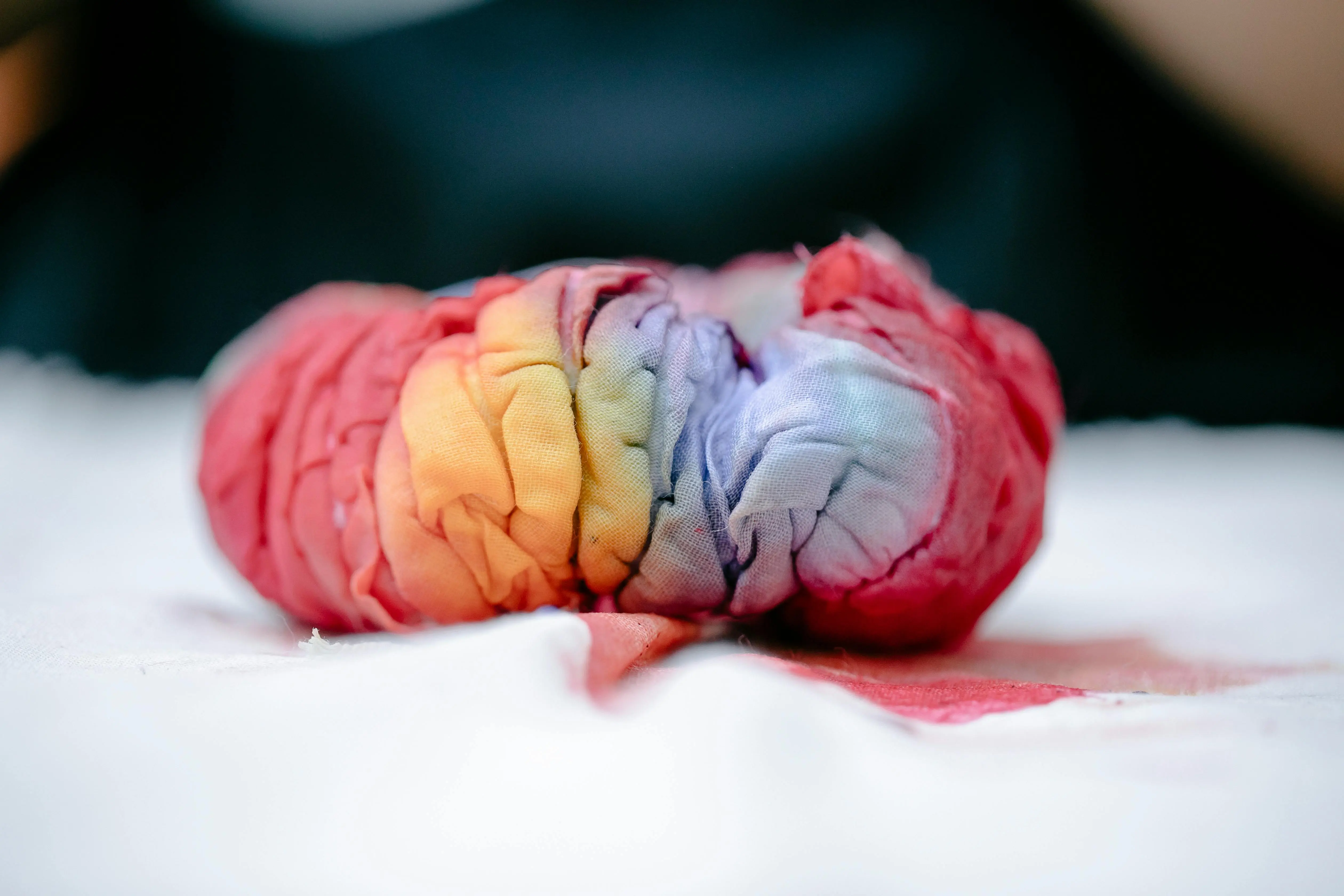 tie dye designs A detailed close-up of vibrant tie-dye fabric showcasing rainbow colors and creased texture.