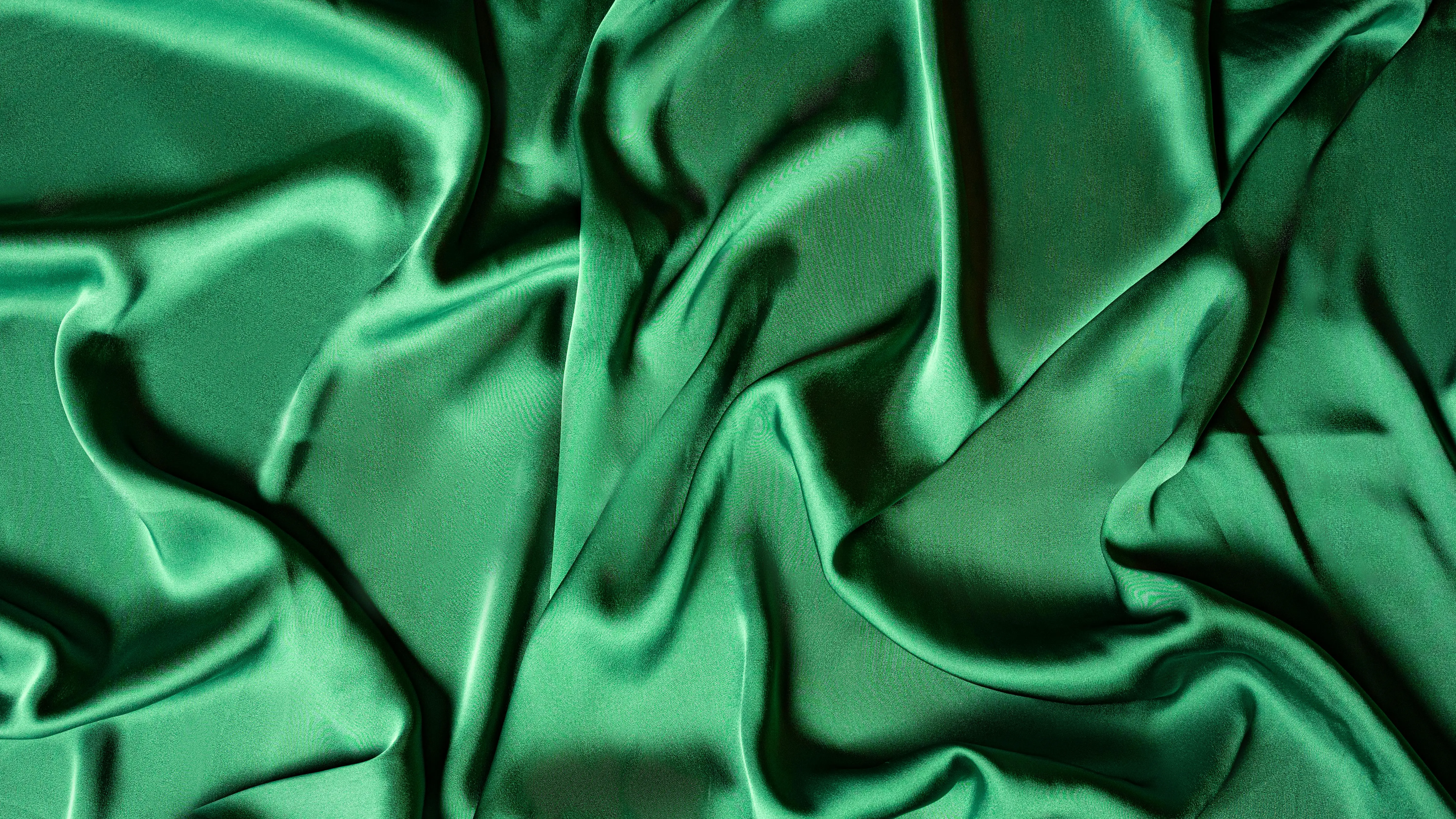 green tile Close-up of crumpled emerald green silk fabric creating a smooth, luxurious texture.