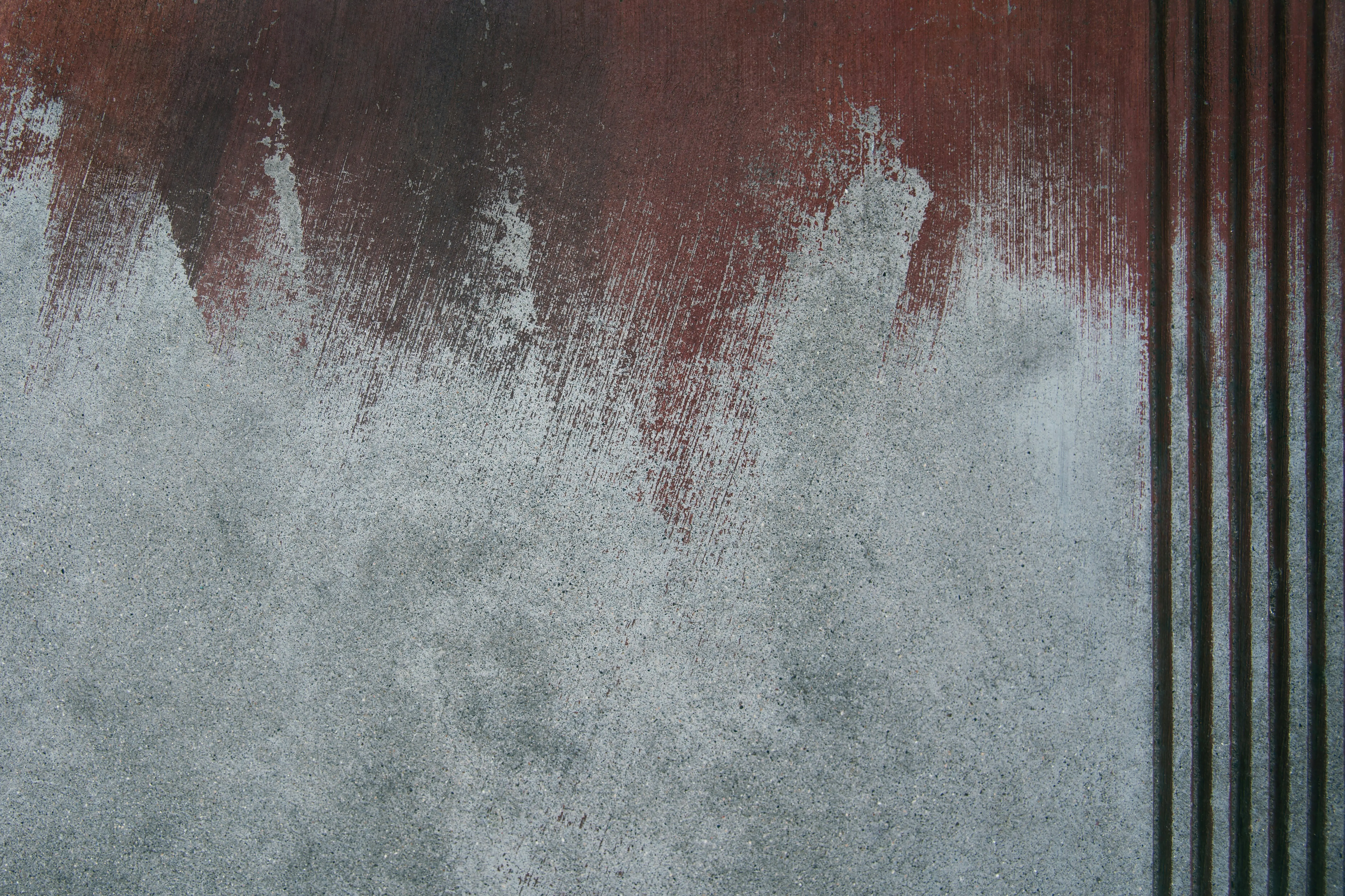 grey paint Close-up of a textured wall with abstract paint strokes and vertical stripes, showcasing concrete surfaces.