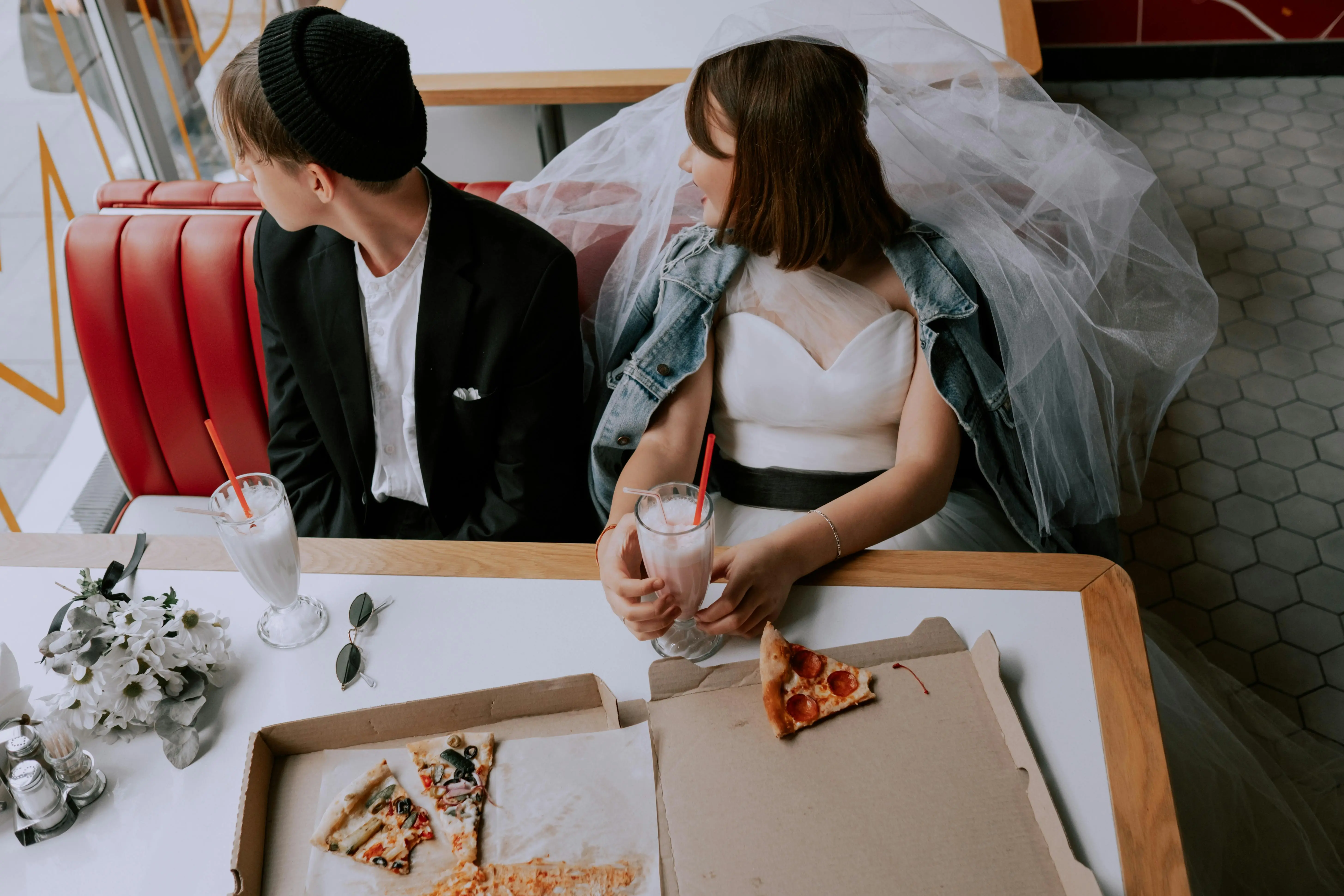 24 hour storage Quirky wedding photo of a bride and groom enjoying pizza and milkshakes in a retro diner.