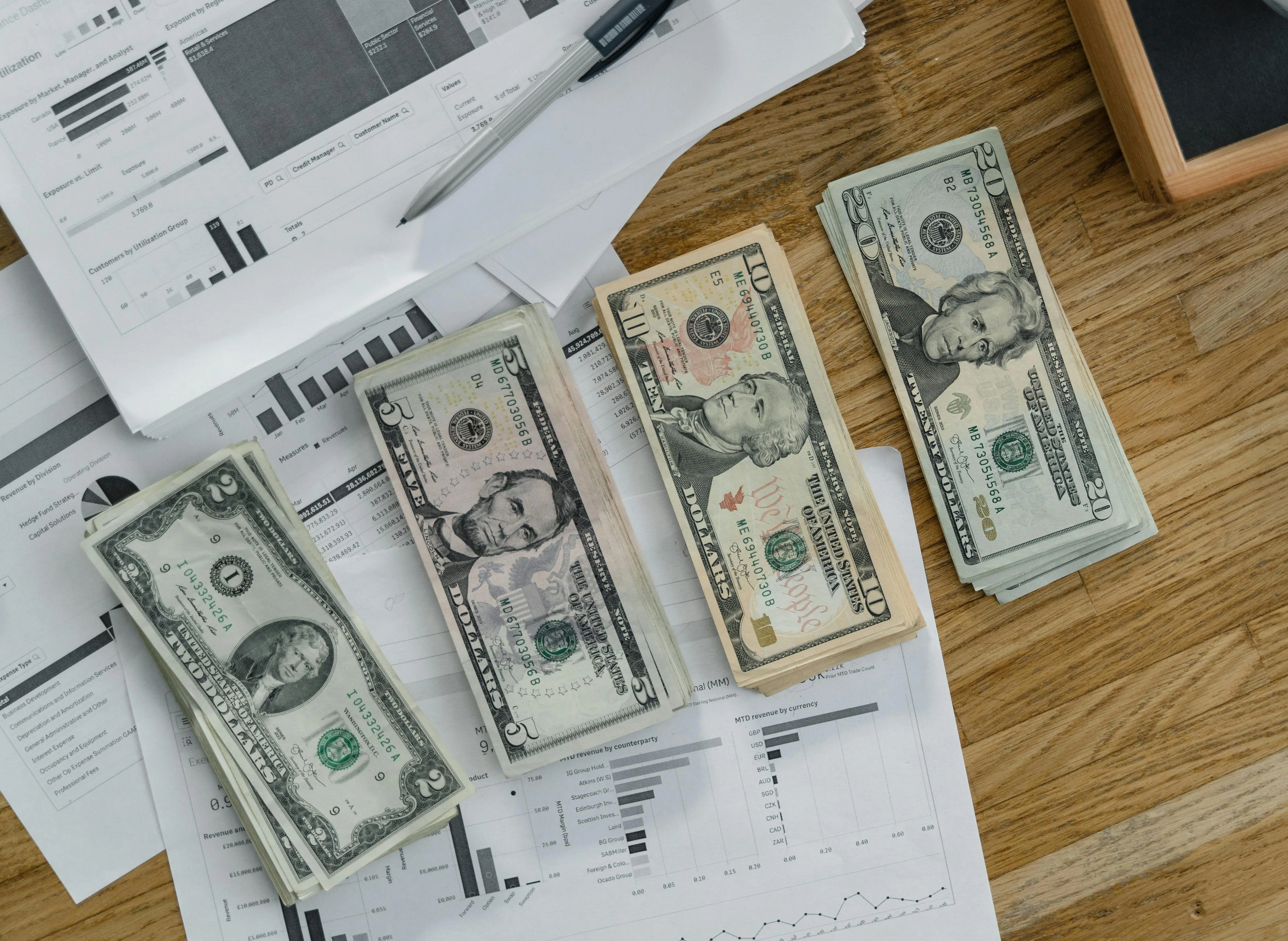 ceiling insulation Stacks of US Dollar banknotes placed over financial documents and reports on a desk.