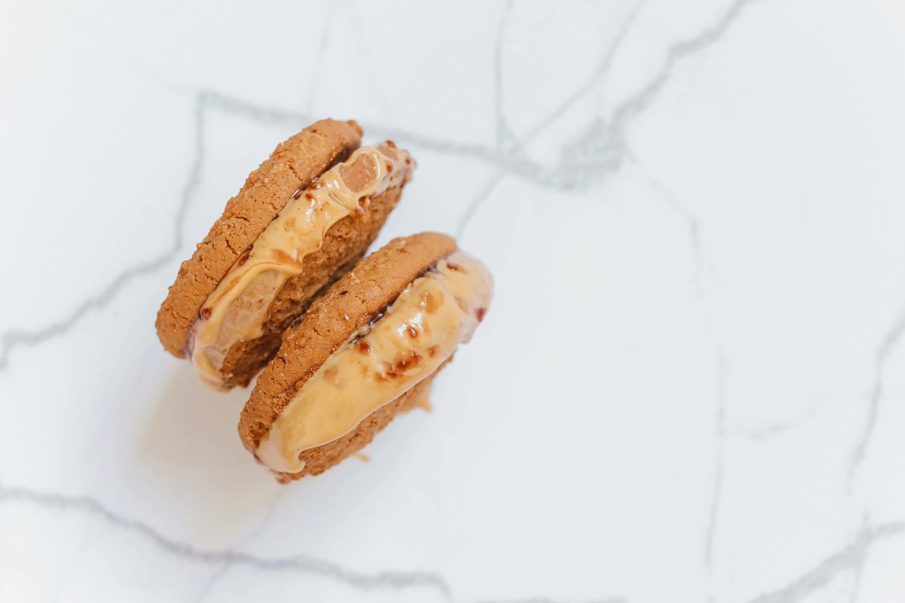 mouse bait Delicious peanut butter-filled cookie sandwich on a marble surface, showcasing creamy indulgence.