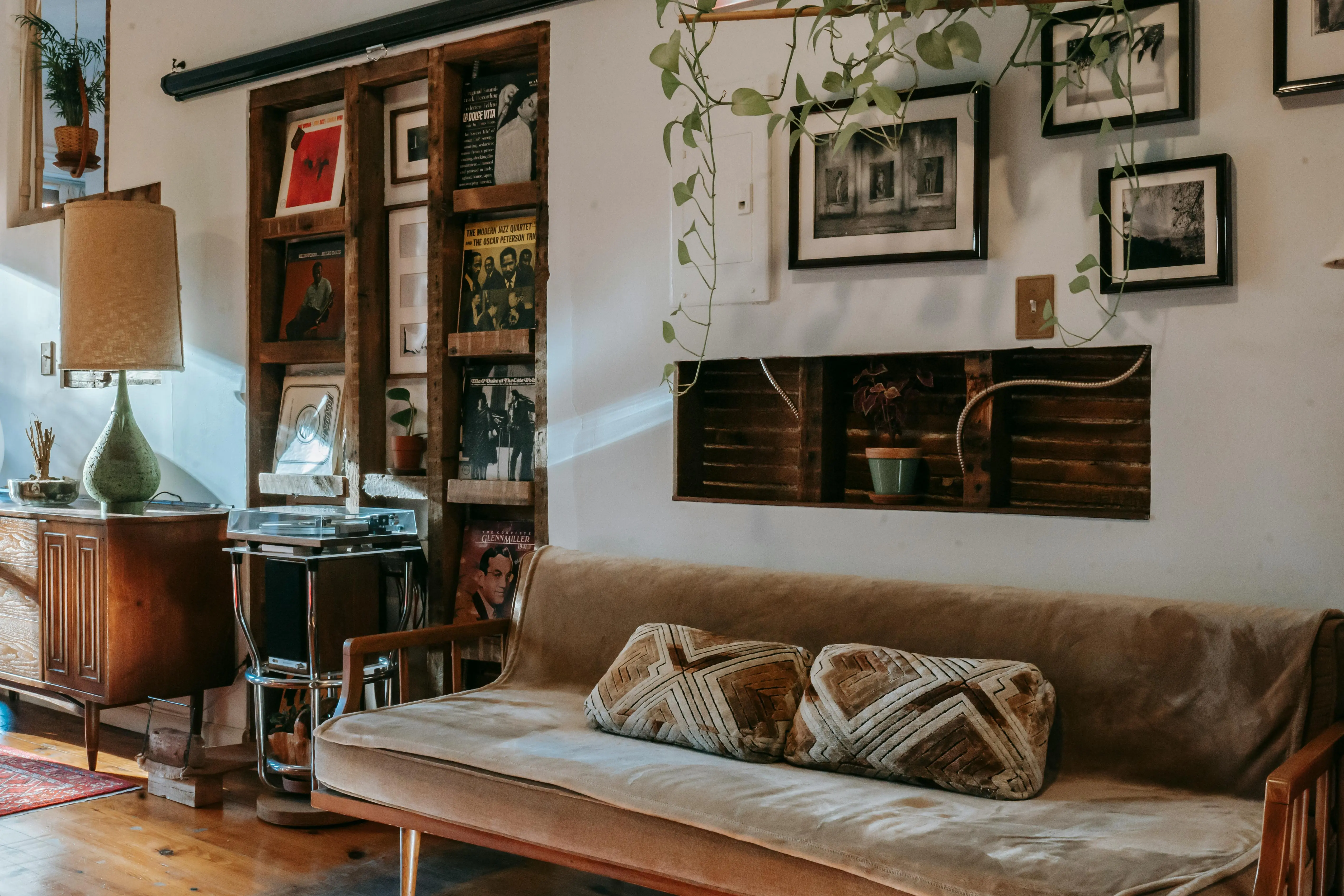 ceiling insulation Interior of stylish living room with comfortable couch placed near shelf with collection of vintage vinyl records and wooden cabinet decorated with classic table lamp