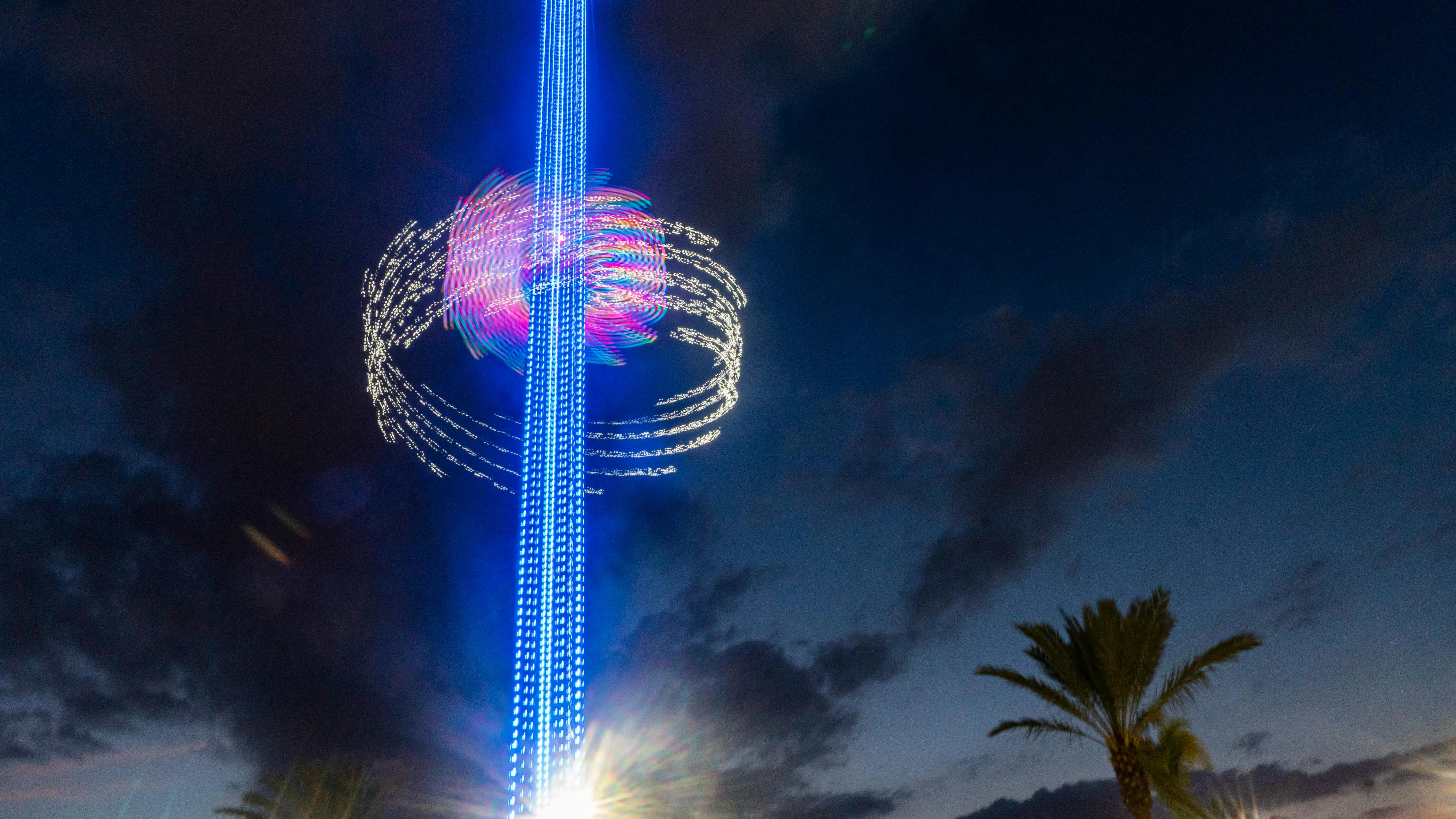 outdoor led strip lights Long exposure of a colorful light tower against a night sky with palm trees below. Captured in Orlando, FL.