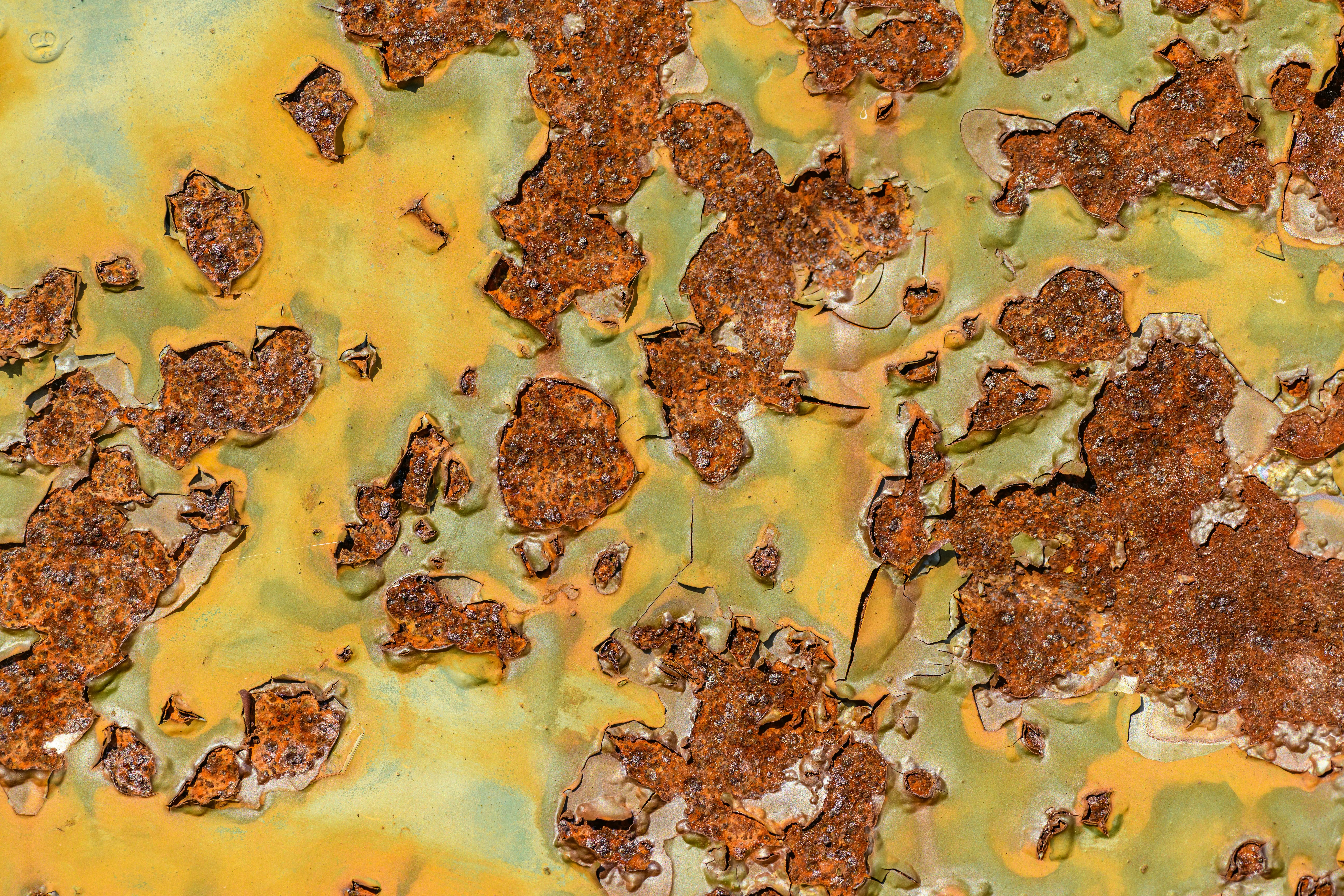 outdoor metal wall art Close-up of a rusty metal surface with vibrant peeling paint texture, ideal for backgrounds and abstract art.