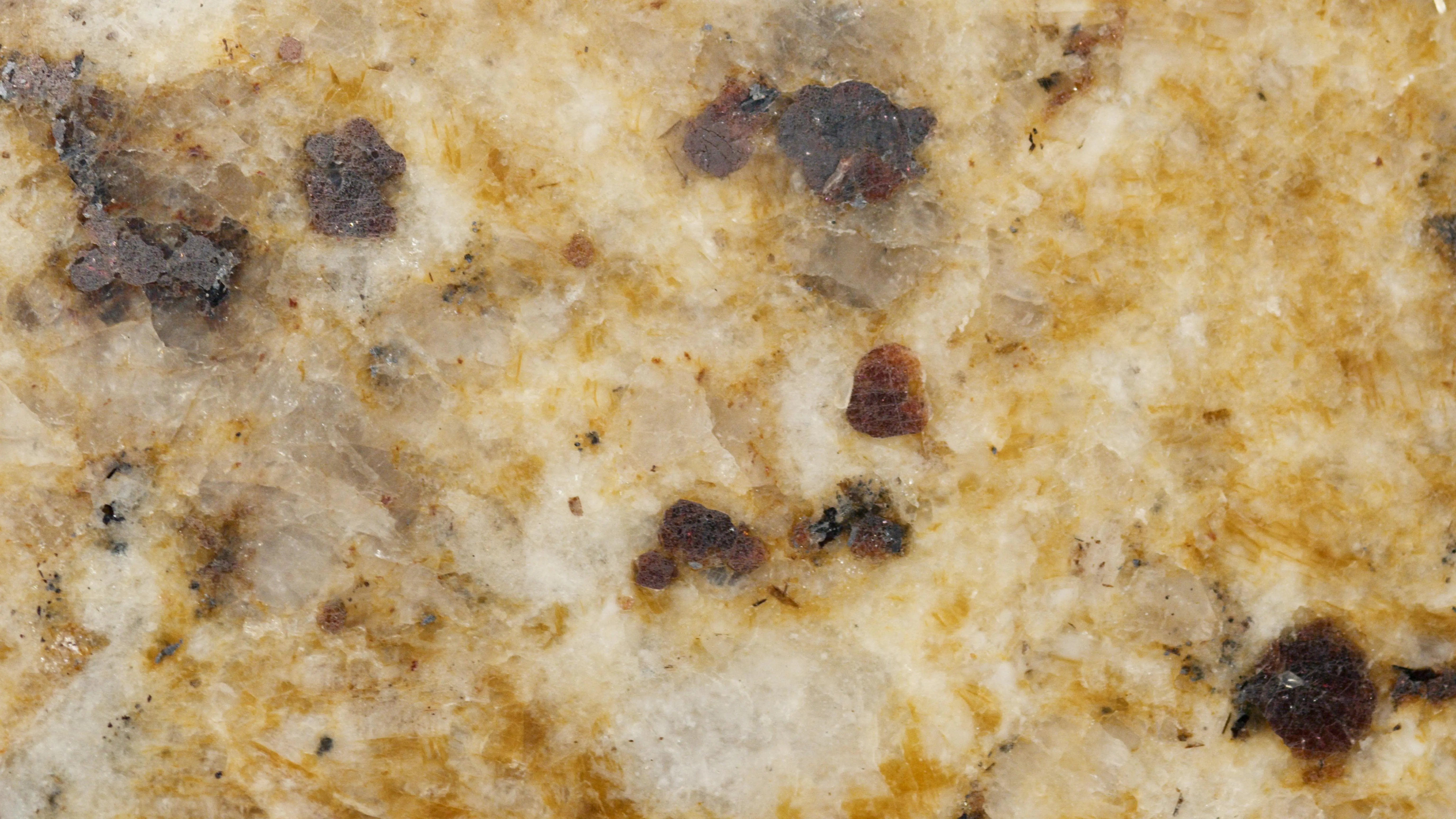 calacatta quartz Detailed close-up of a textured granite surface with earthy tones and patterns.