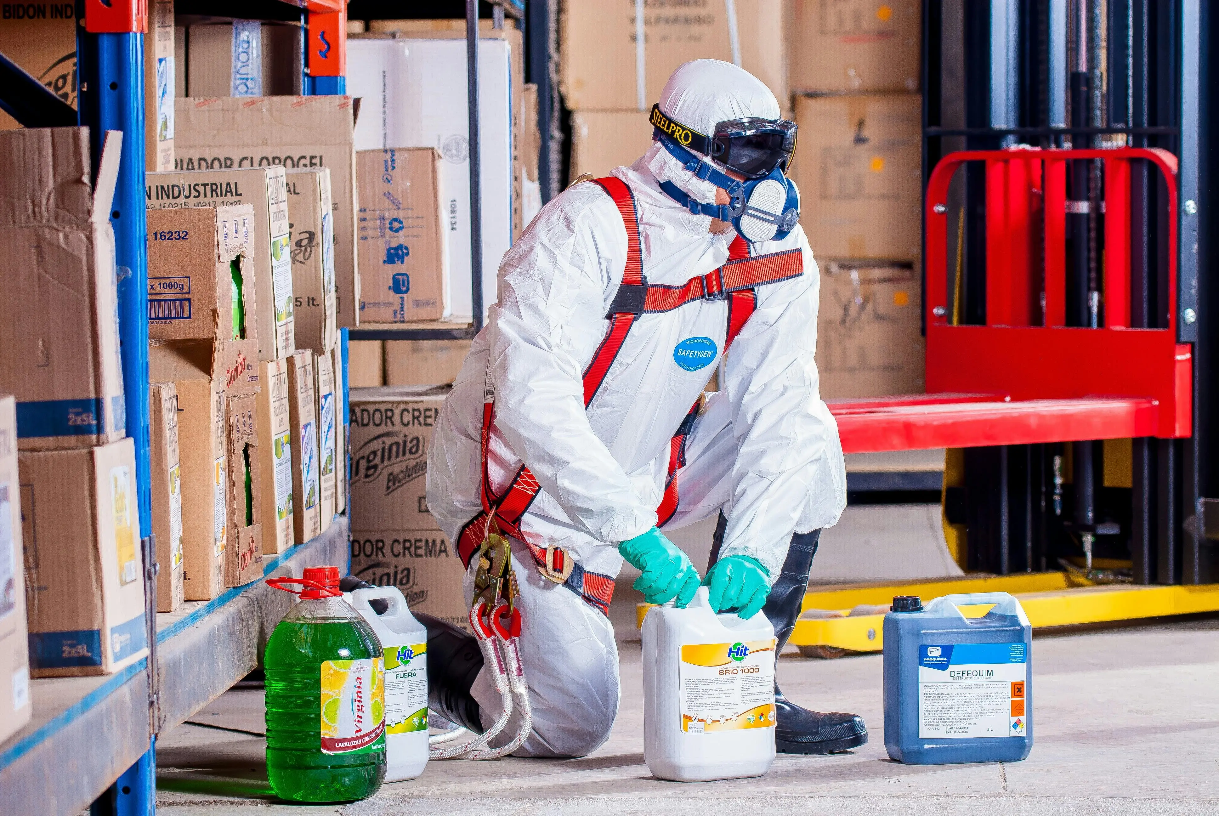 rat poison box Industrial worker in protective gear handling chemicals in a warehouse environment.