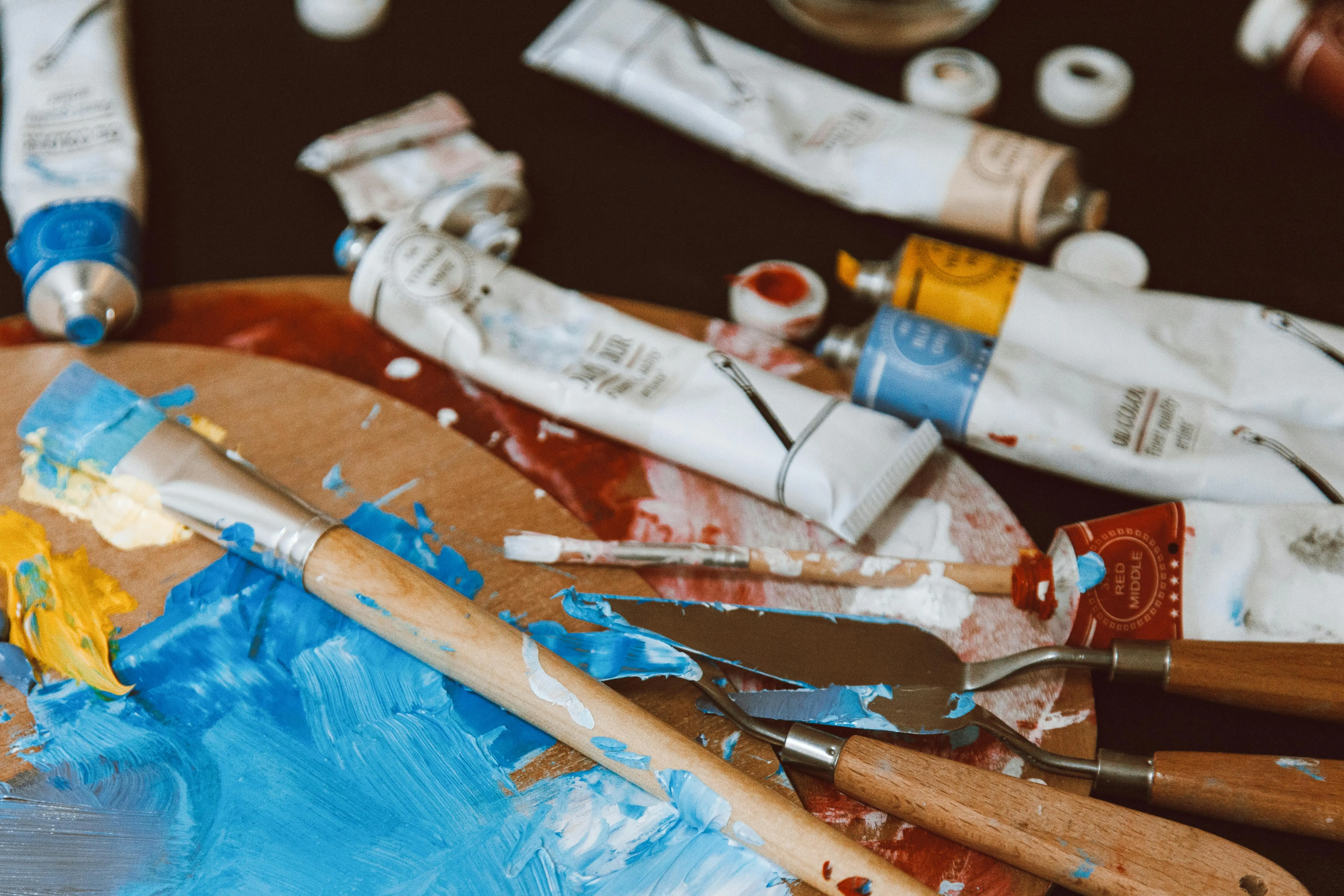 what to paint A close-up of a colorful artist's palette with paintbrushes and paint tubes, vibrant and inspiring.