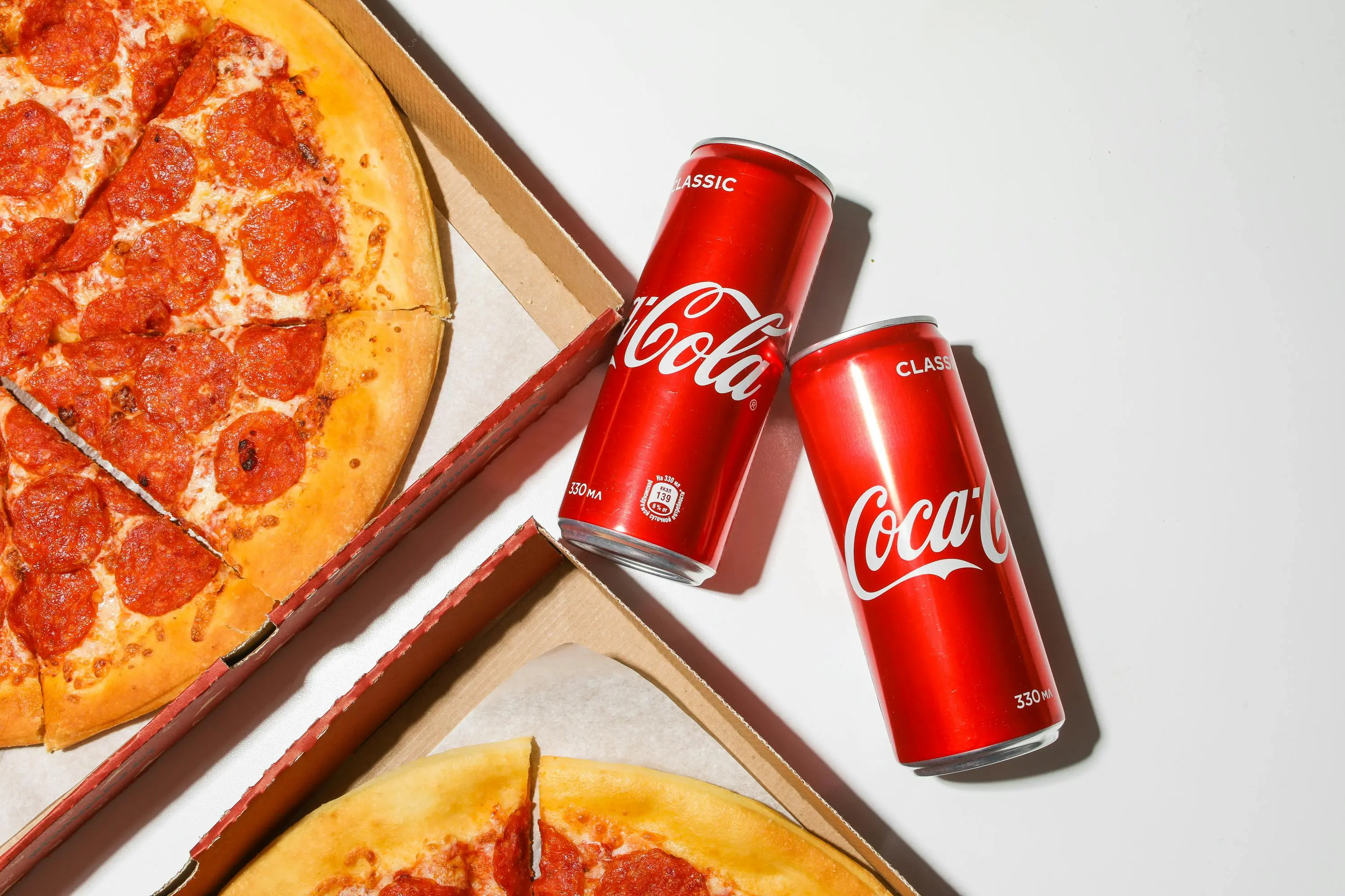 how to get smoke smell out of clothes Close-up shot of pepperoni pizza and Coca-Cola cans, perfect fast food combo.