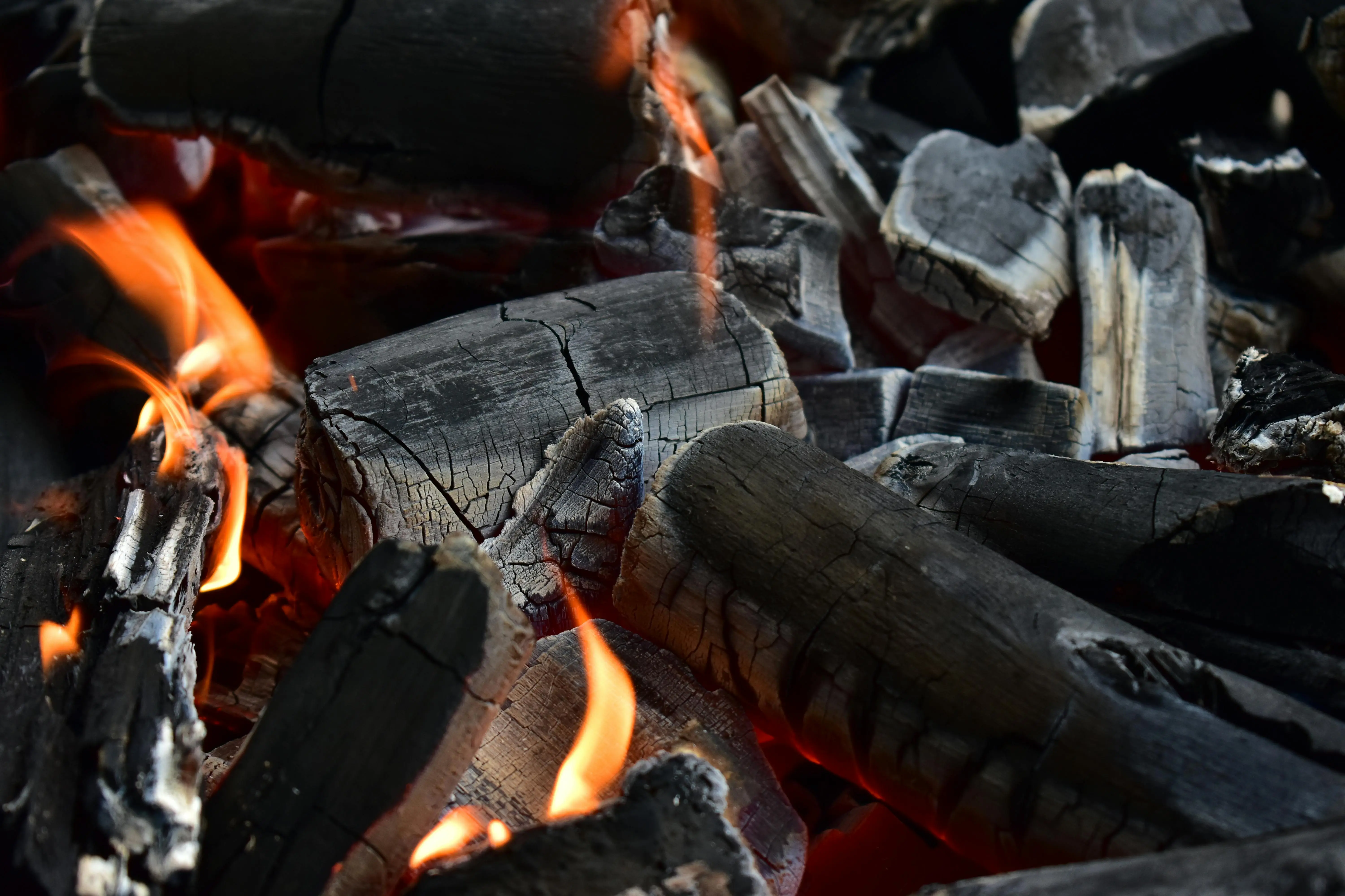 how to get deodorant stains out of black shirts Detailed shot of glowing charcoal embers with vibrant flames against a dark background.