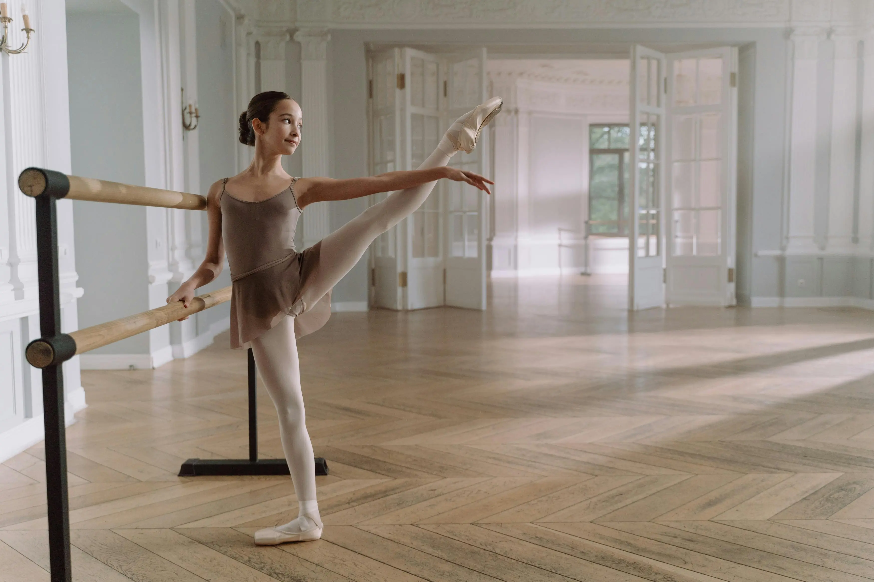diy dance floor A young ballerina gracefully stretches at a barre in a sunlit, elegant dance studio.