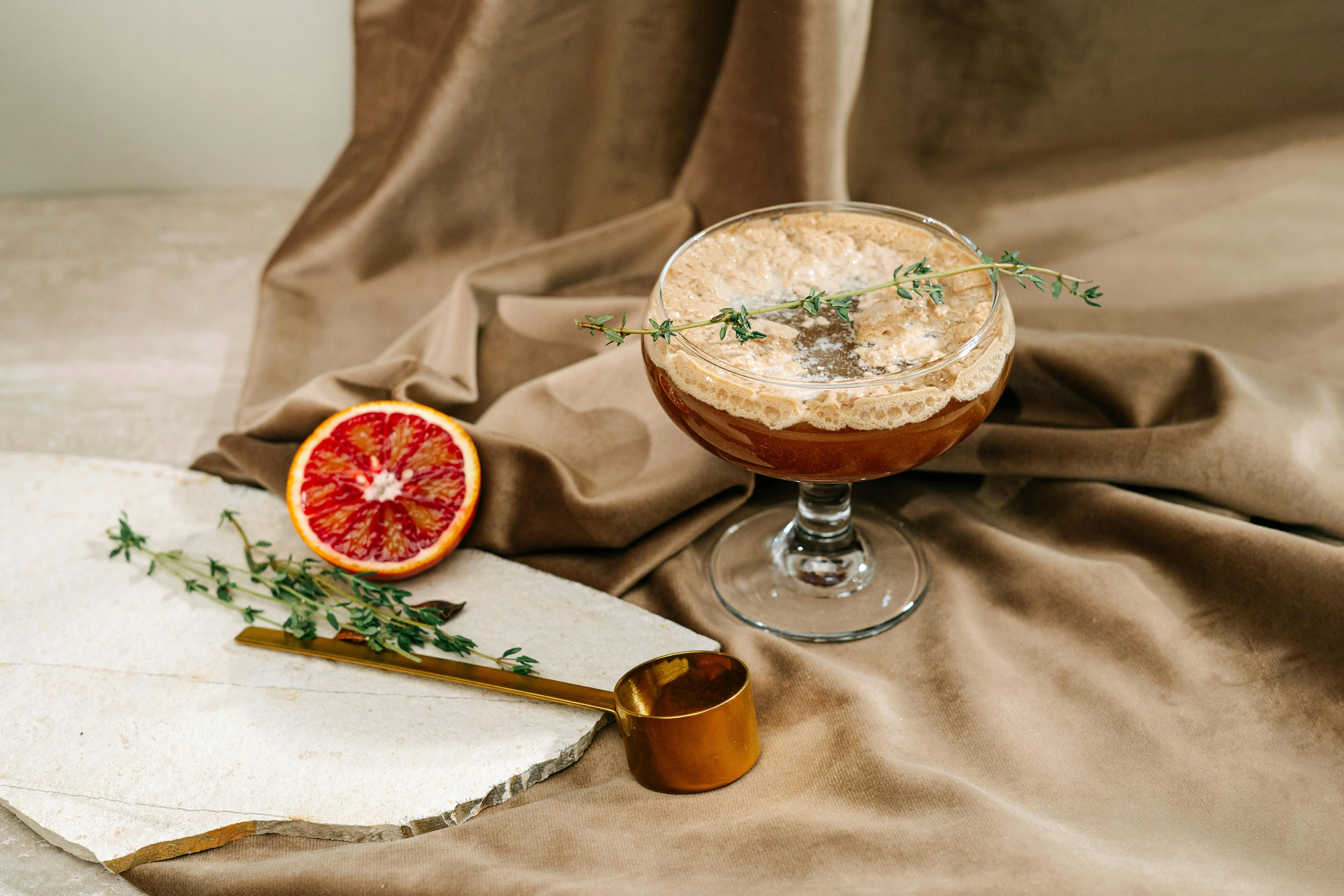 how to get blood out of jeans A sophisticated cocktail on a fabric backdrop with blood orange and herbs.