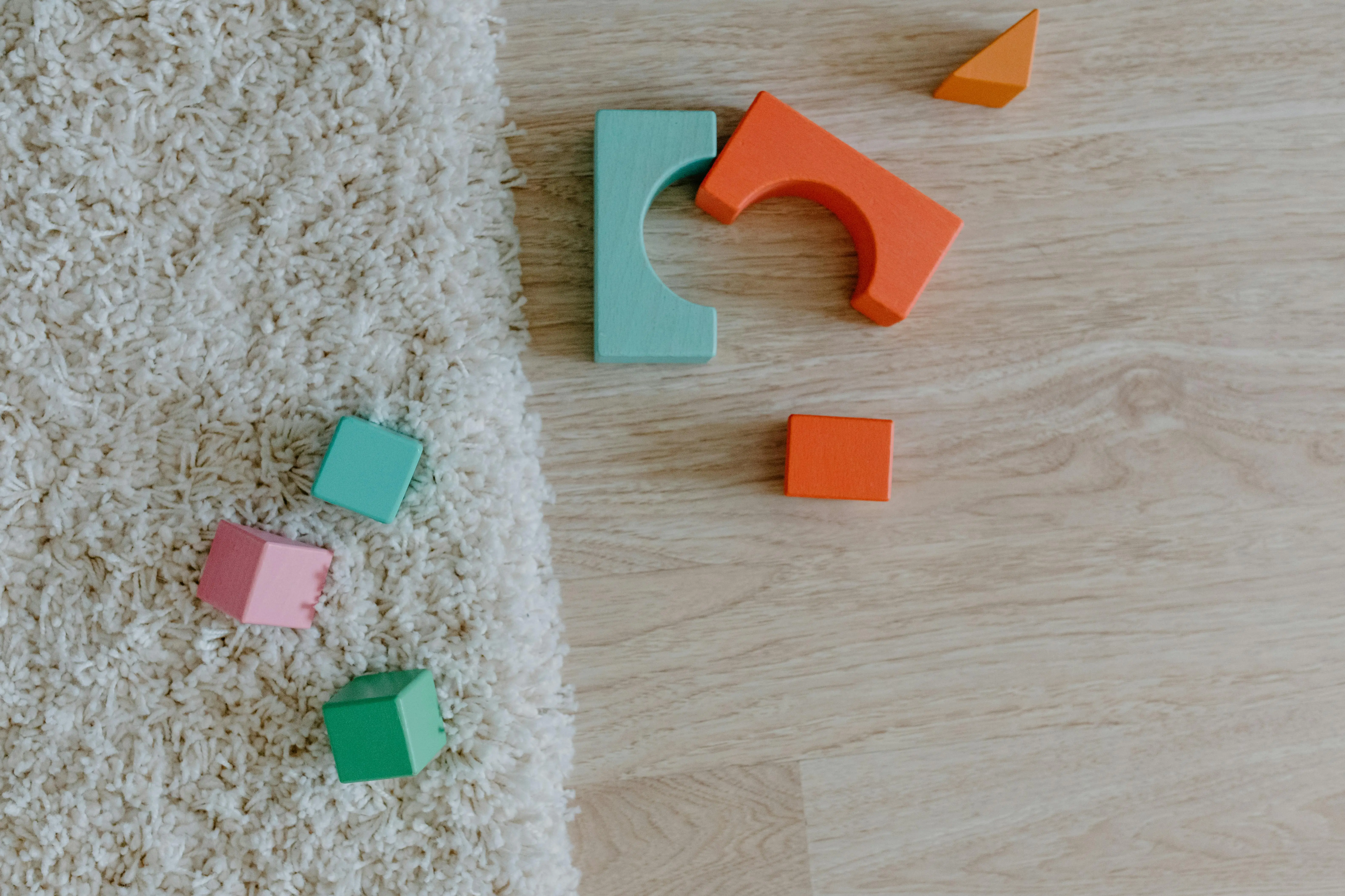 easy sip and paint ideas Close-up of colorful wooden blocks on a carpet and wooden floor.