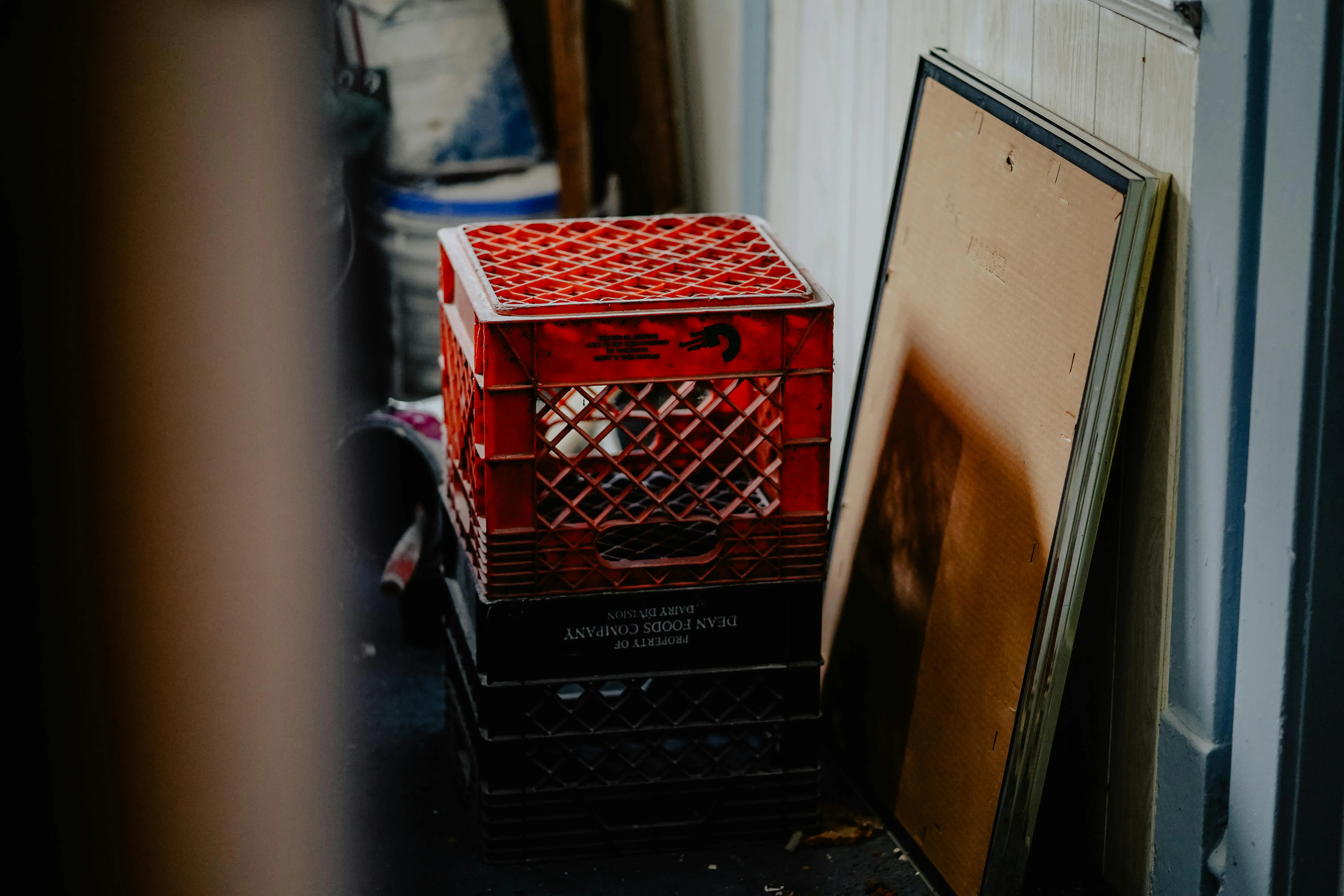lift top cocktail table Stacked red crates and frames in an industrial backroom setting.