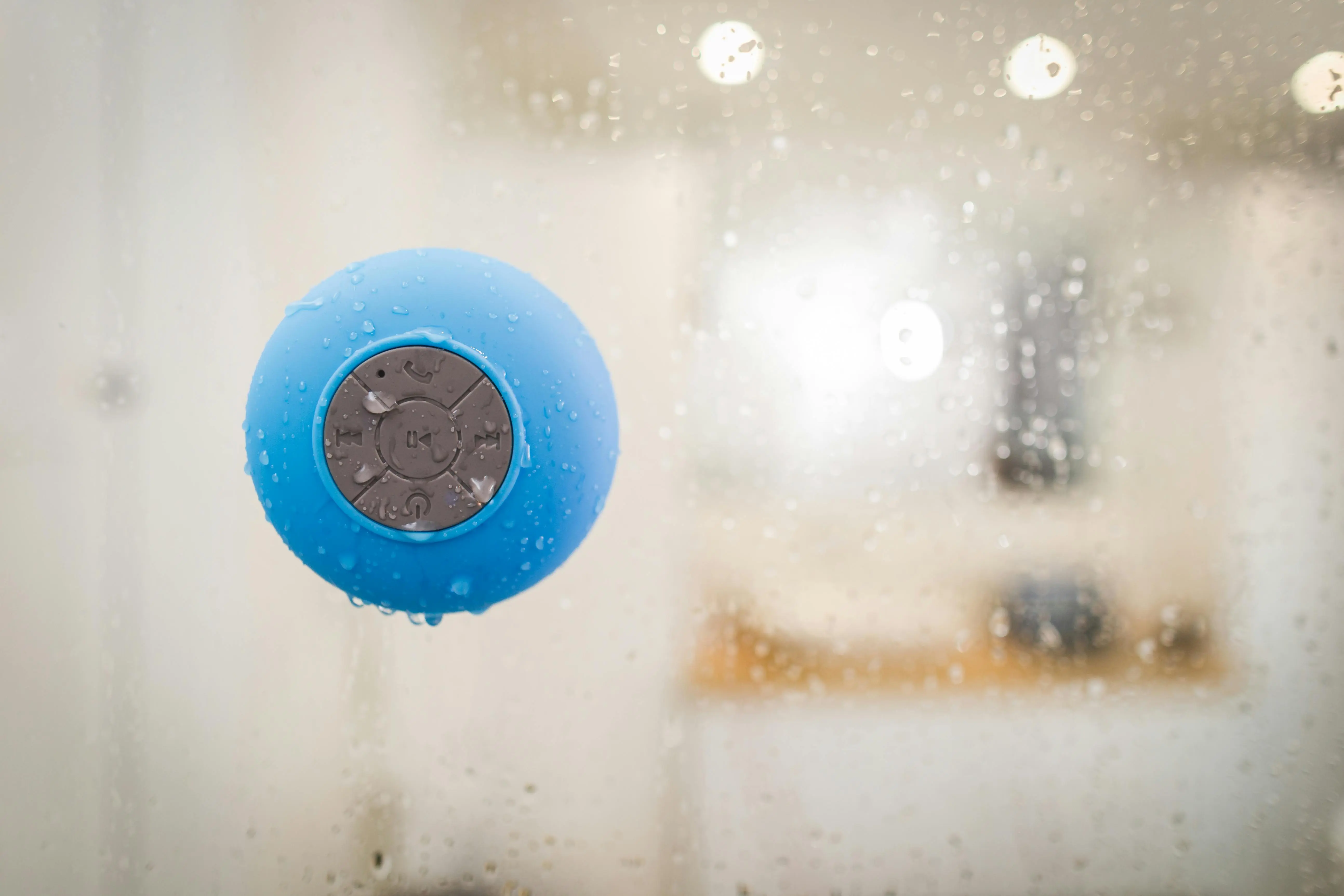 bathroom light fixtures brushed nickel Close-up of a blue Bluetooth speaker with water droplets, ideal for showers.