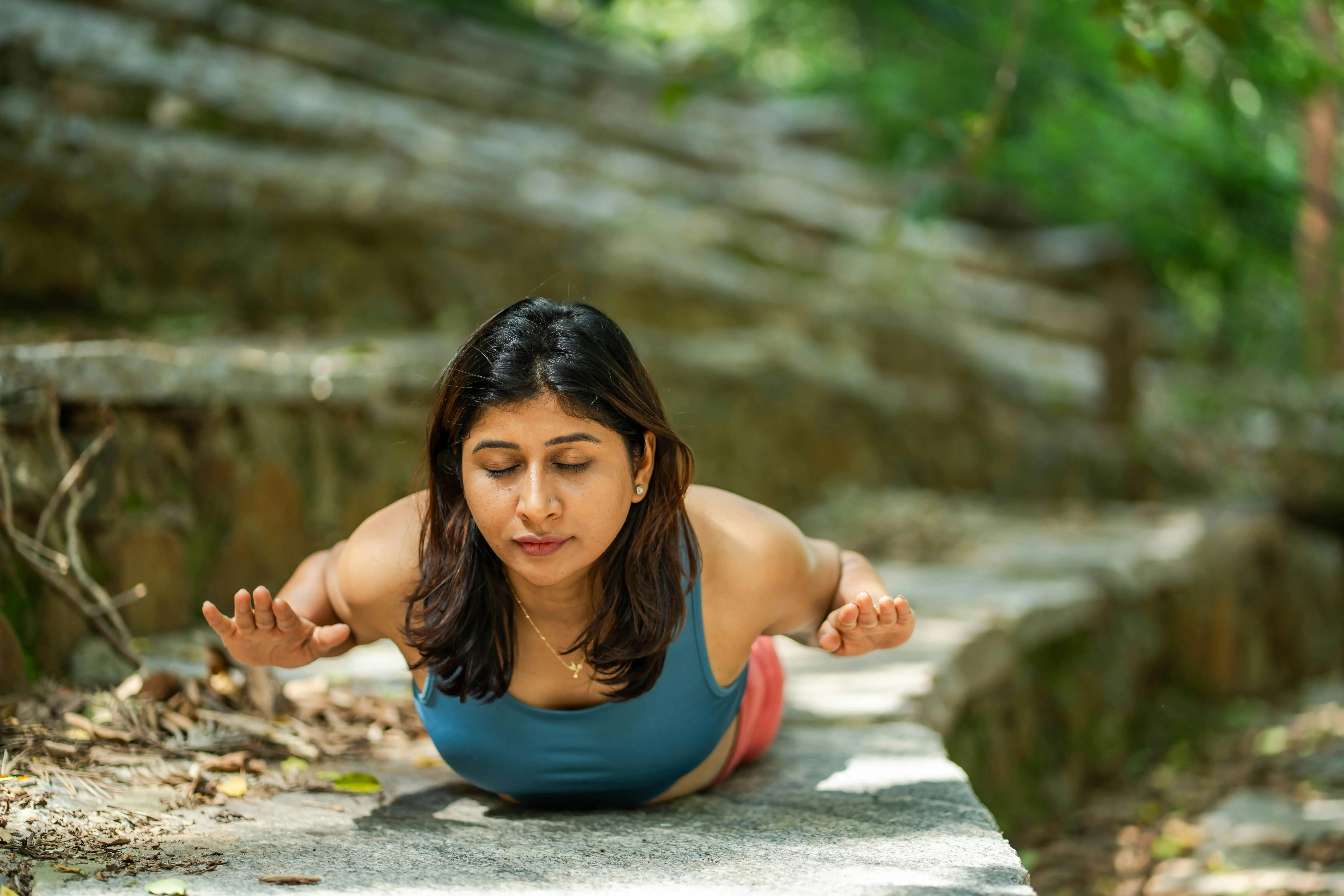 low voltage pathway lights A woman practicing yoga outdoors in a serene setting, performing the Cobra Pose on a stone pathway.