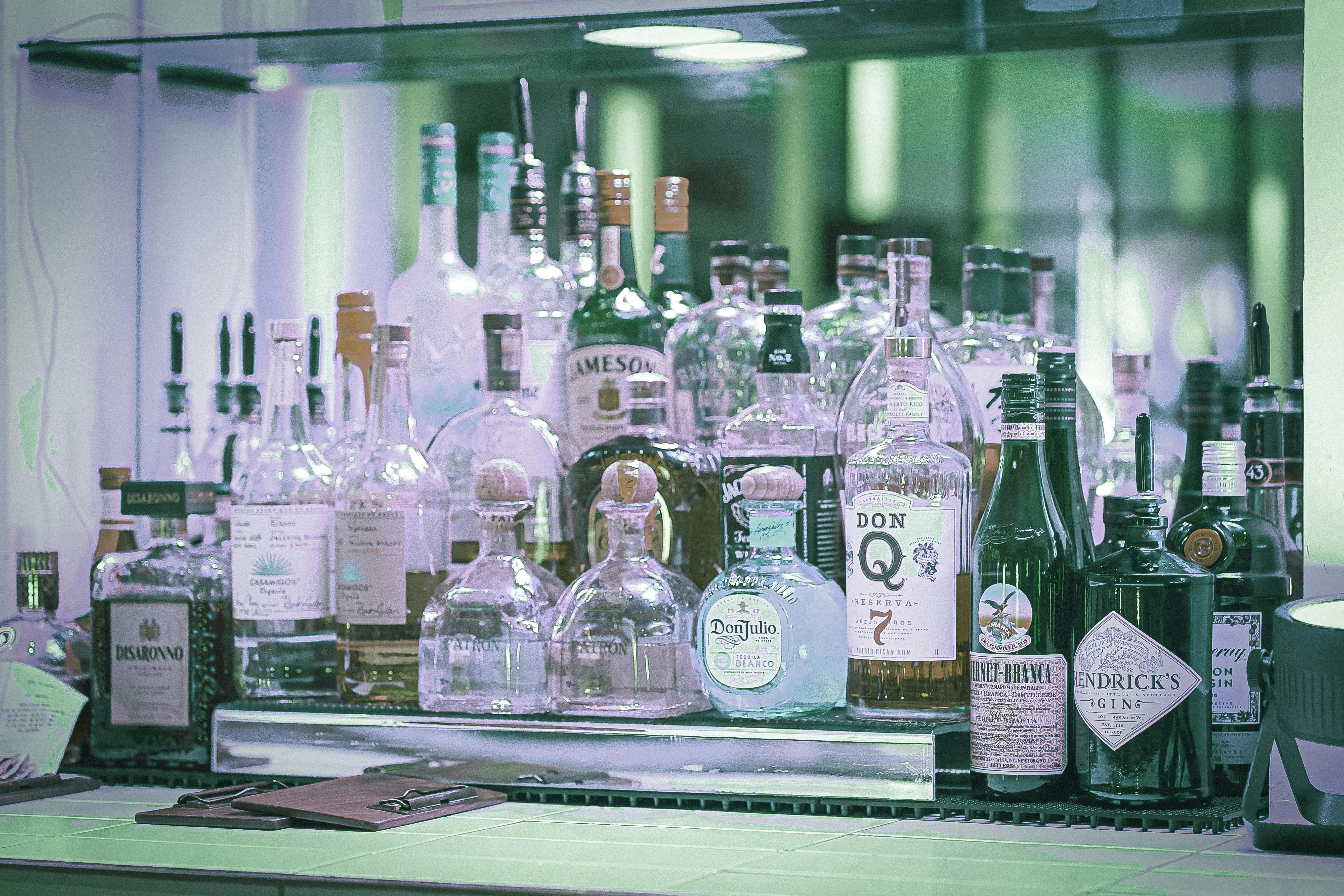 large bouquet A diverse selection of liquor bottles displayed on a bar shelf, showcasing various brands and types.