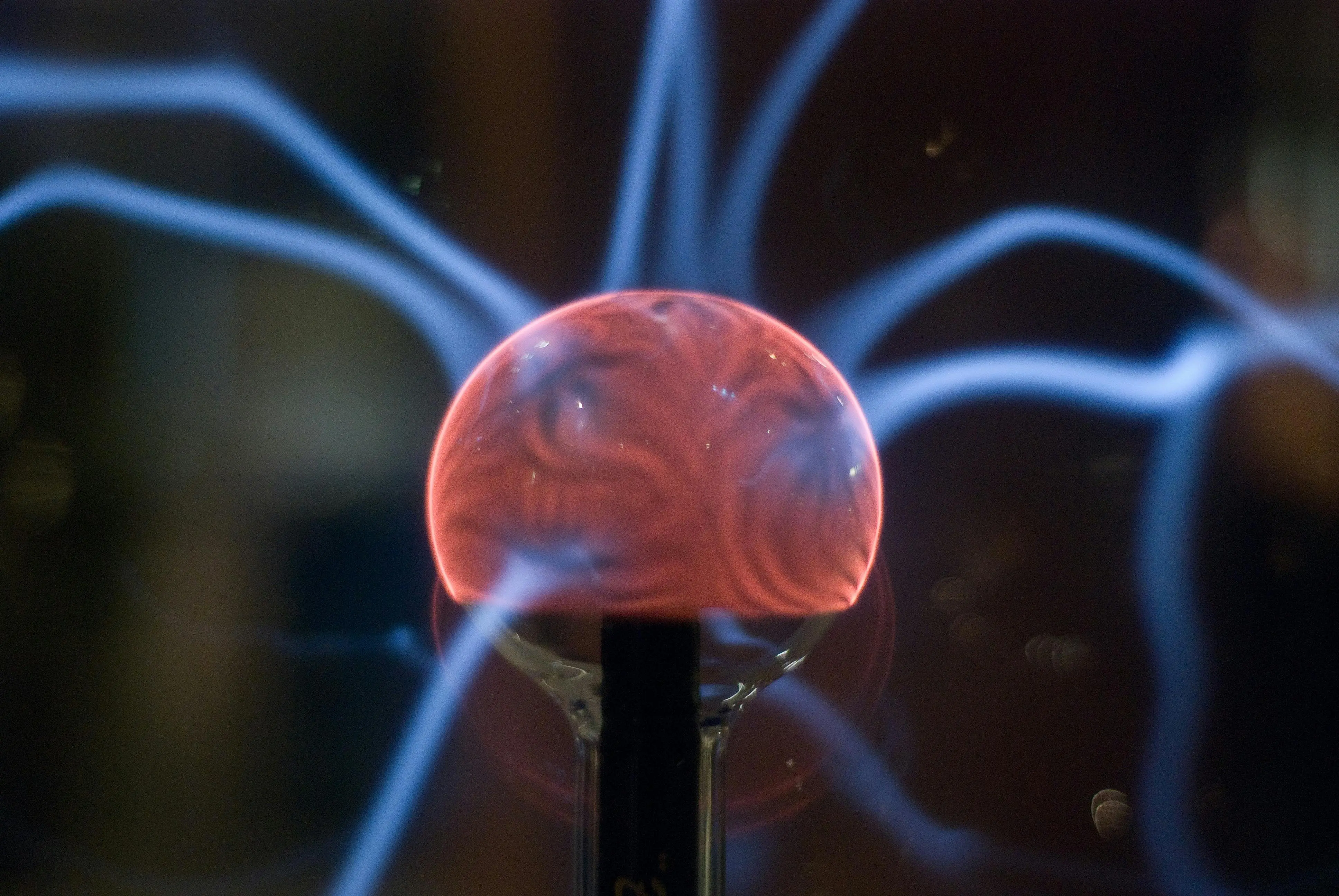 how to get rid of static electricity Close-up view of a plasma ball exhibiting mesmerizing electric arcs in a dark setting.