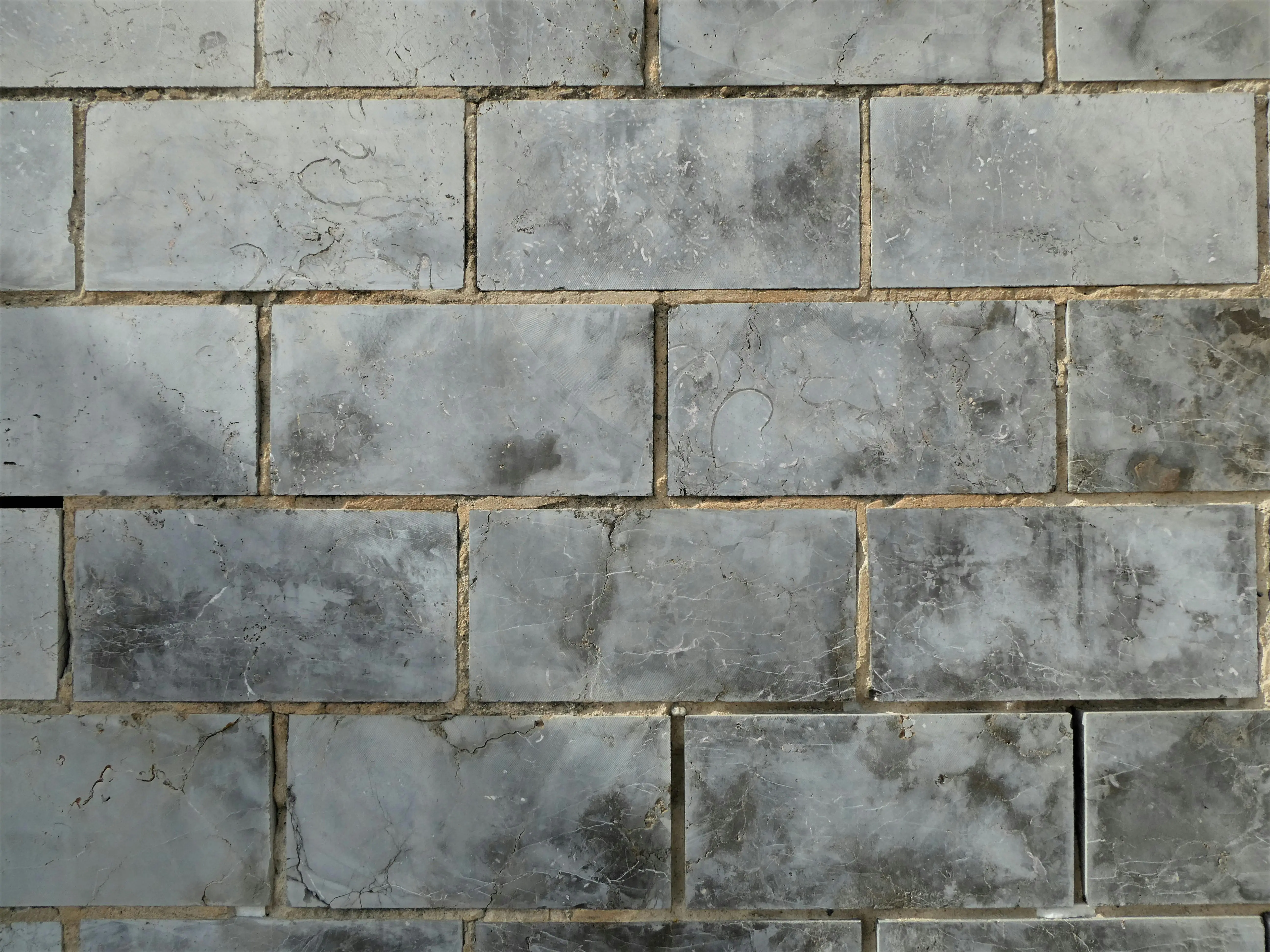 peel and stick stone tile Close-up of textured ceramic wall tiles forming a uniform pattern.
