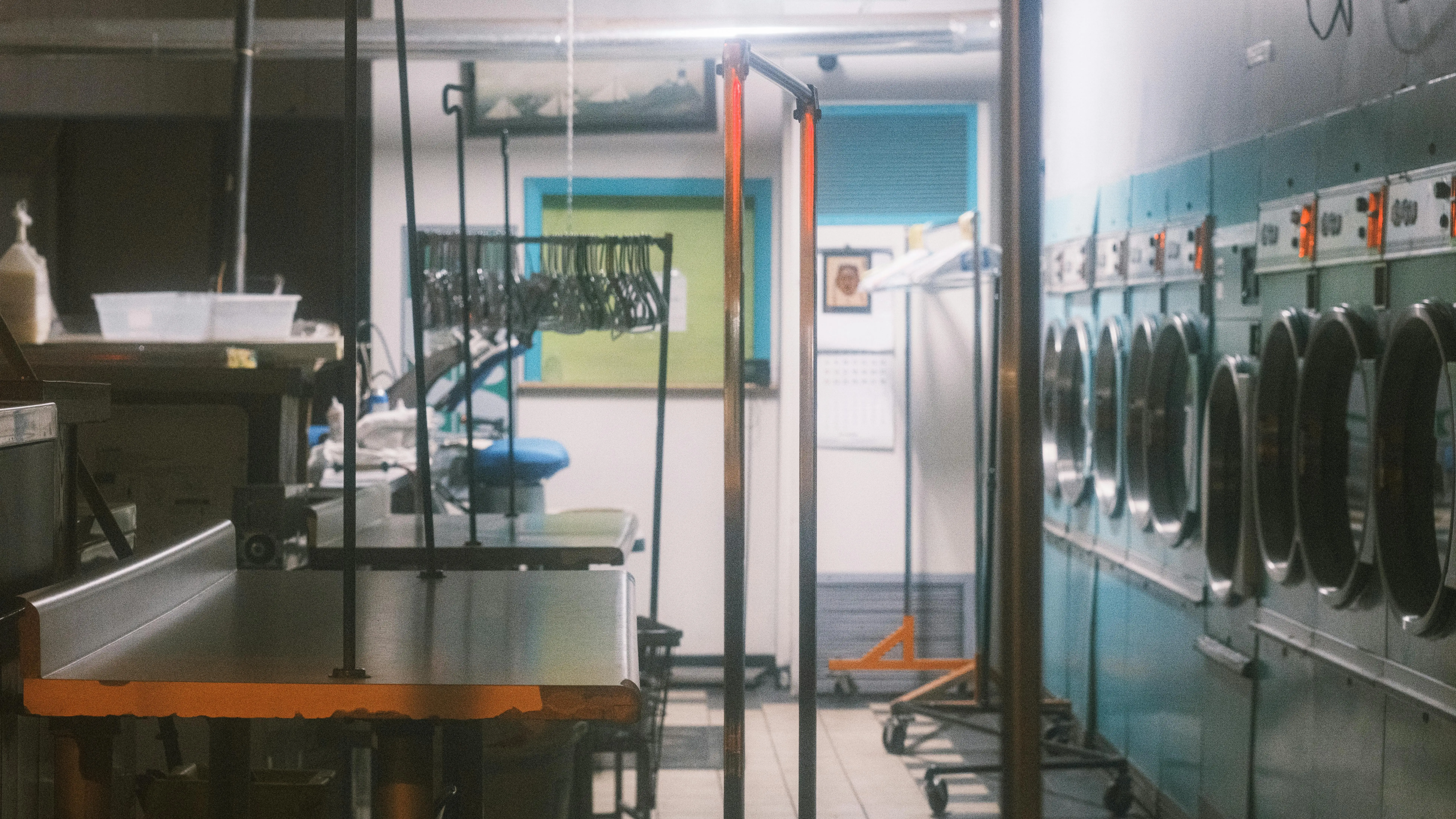 rv stackable washer and dryer Interior view of a commercial laundry facility with machines and clothing racks.