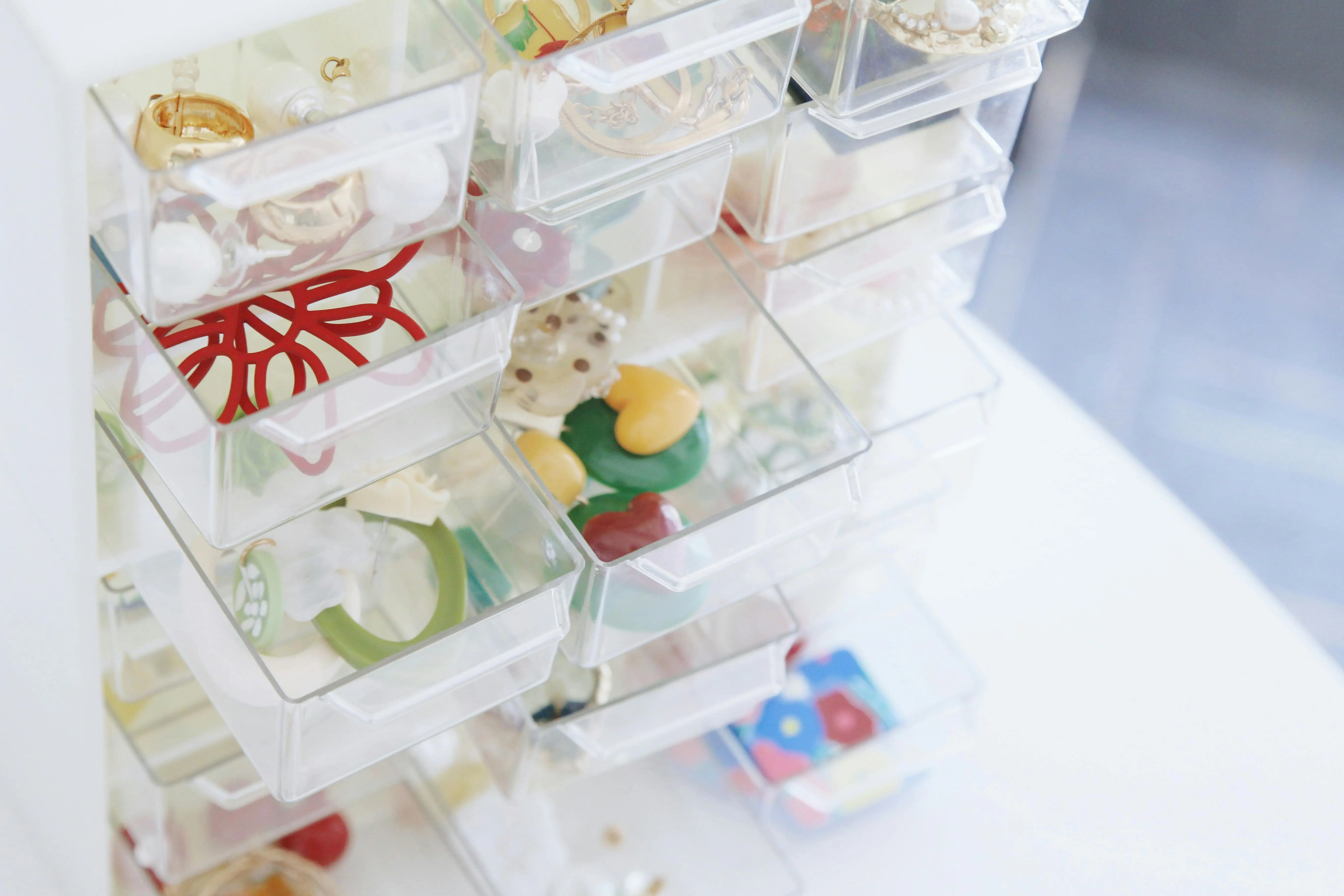 vanity drawer organizer A collection of colorful jewelry pieces organized in transparent storage drawers.