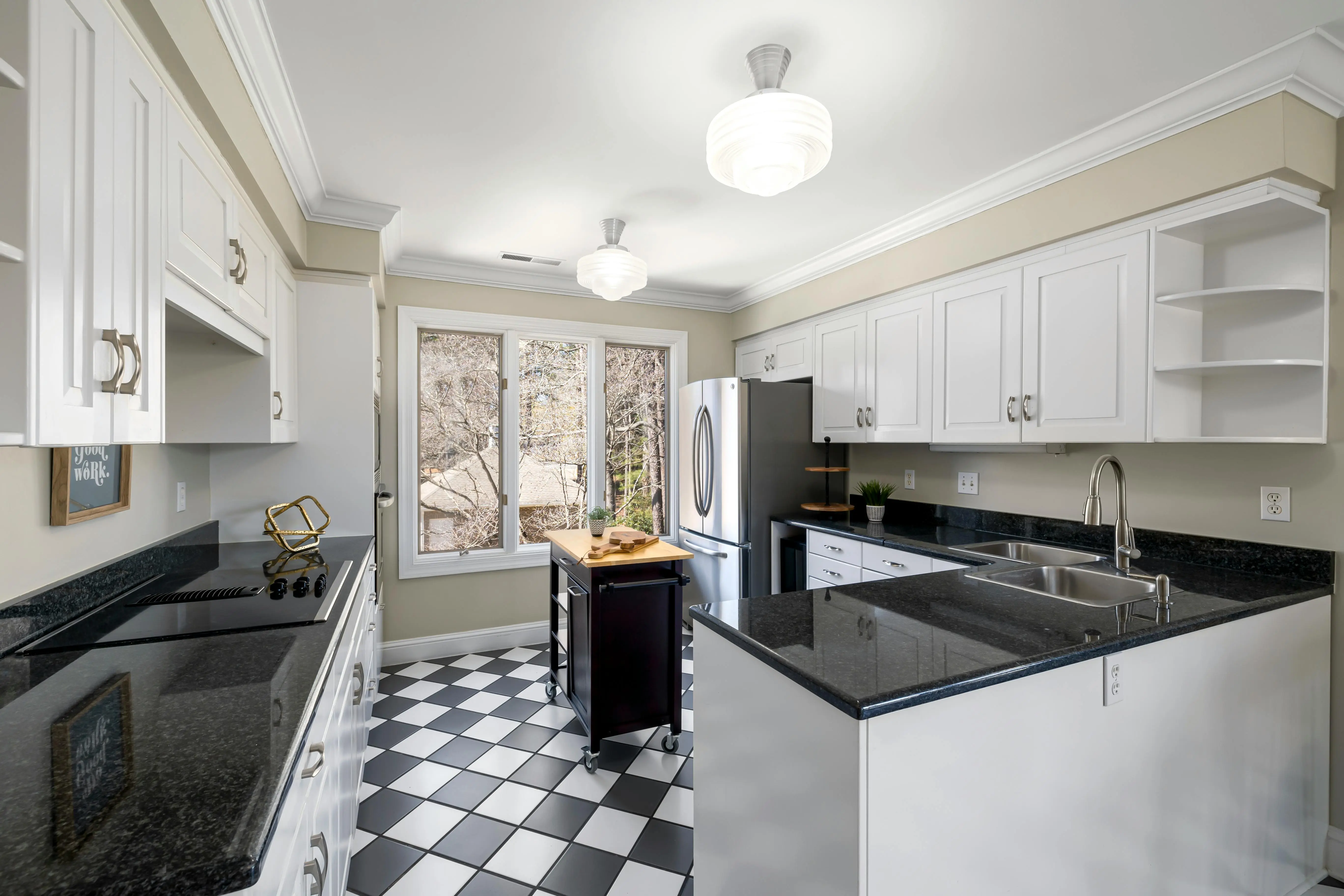 black and white backsplash White kitchen with checkered floor, sleek counters, and natural light.