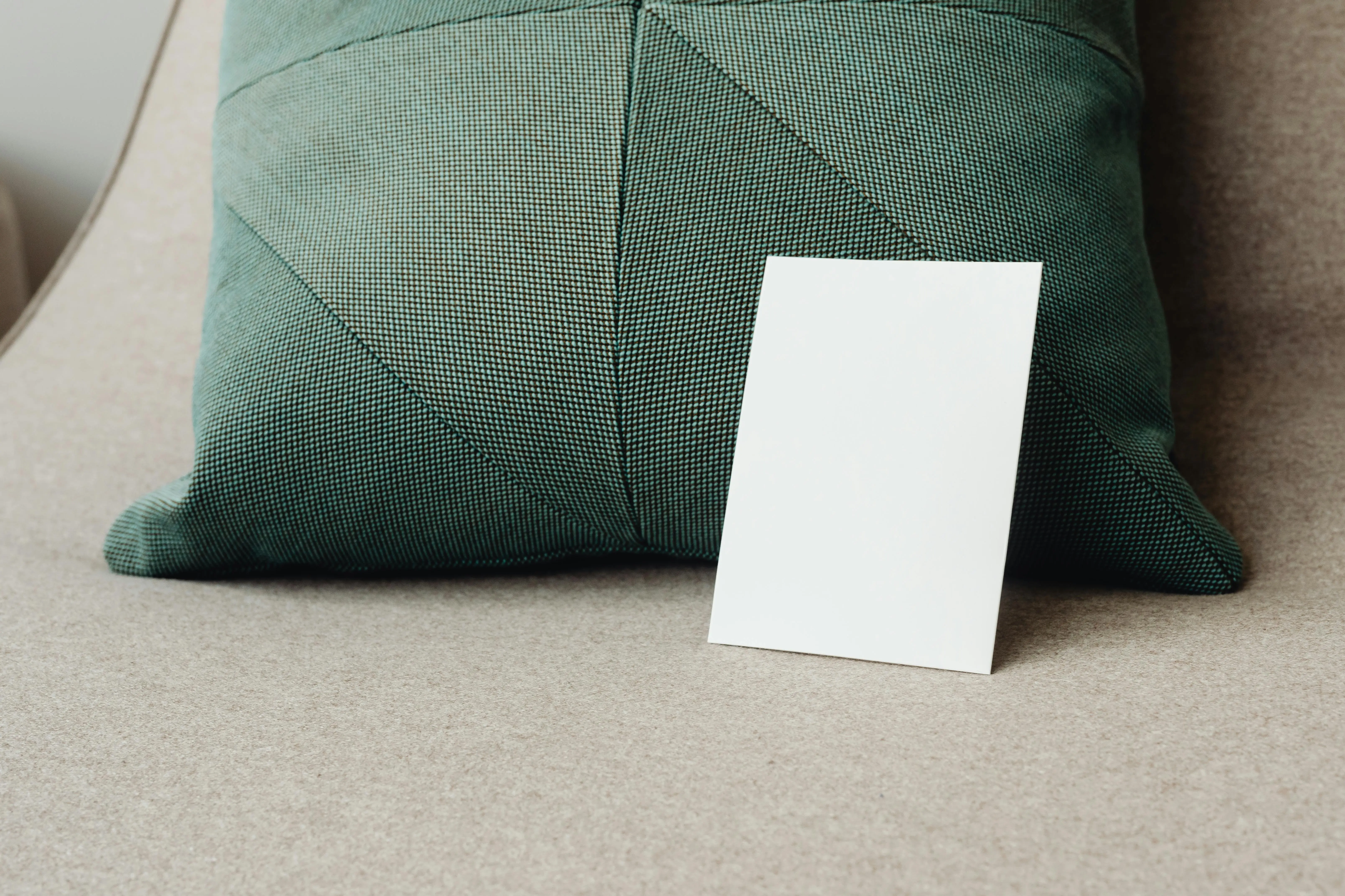 blue and white pillows A minimalist mockup featuring a blank white card against a textured green pillow.