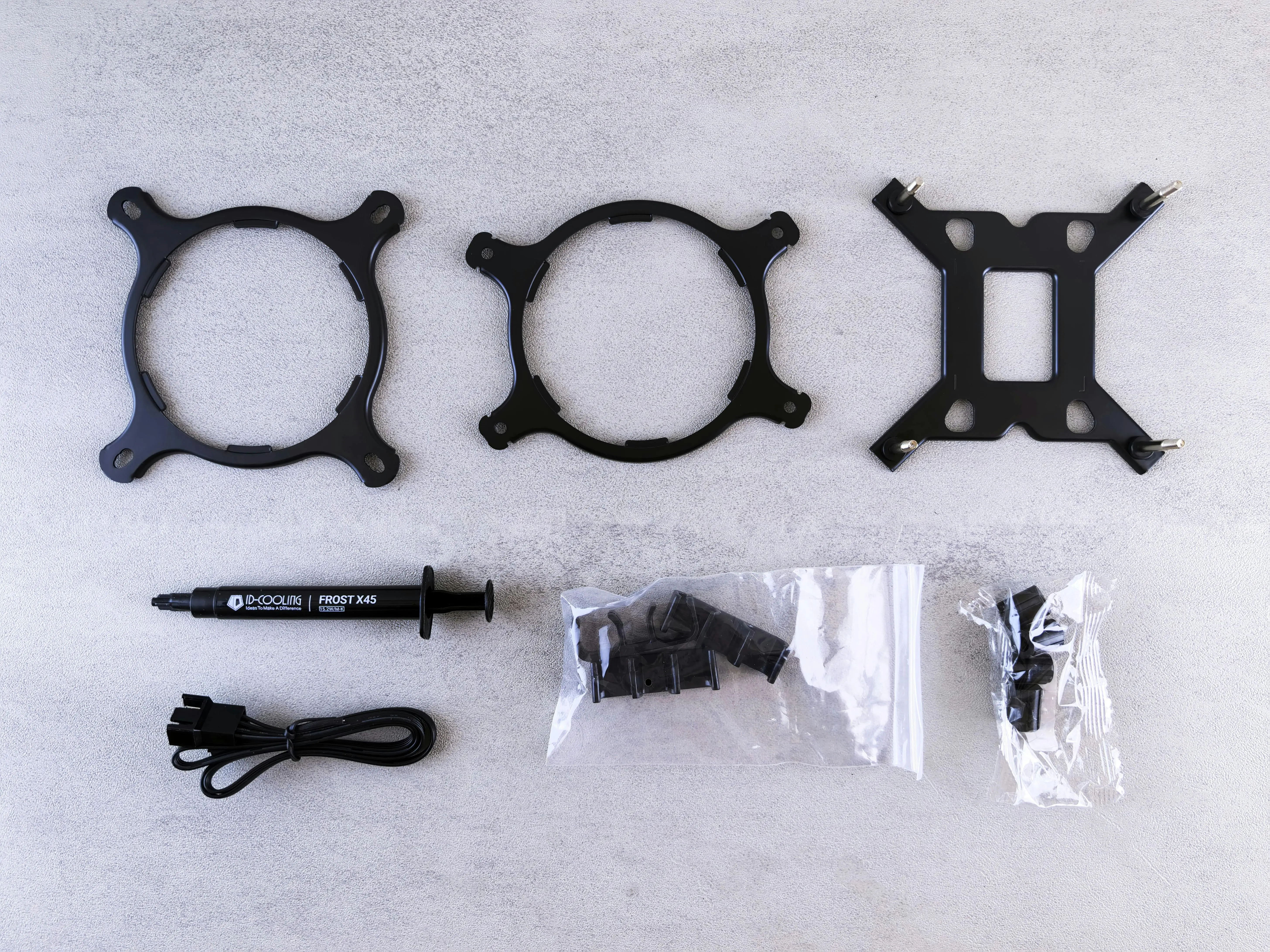 shelf and rod bracket Top view of computer cooling kit components including brackets, paste, and cables.