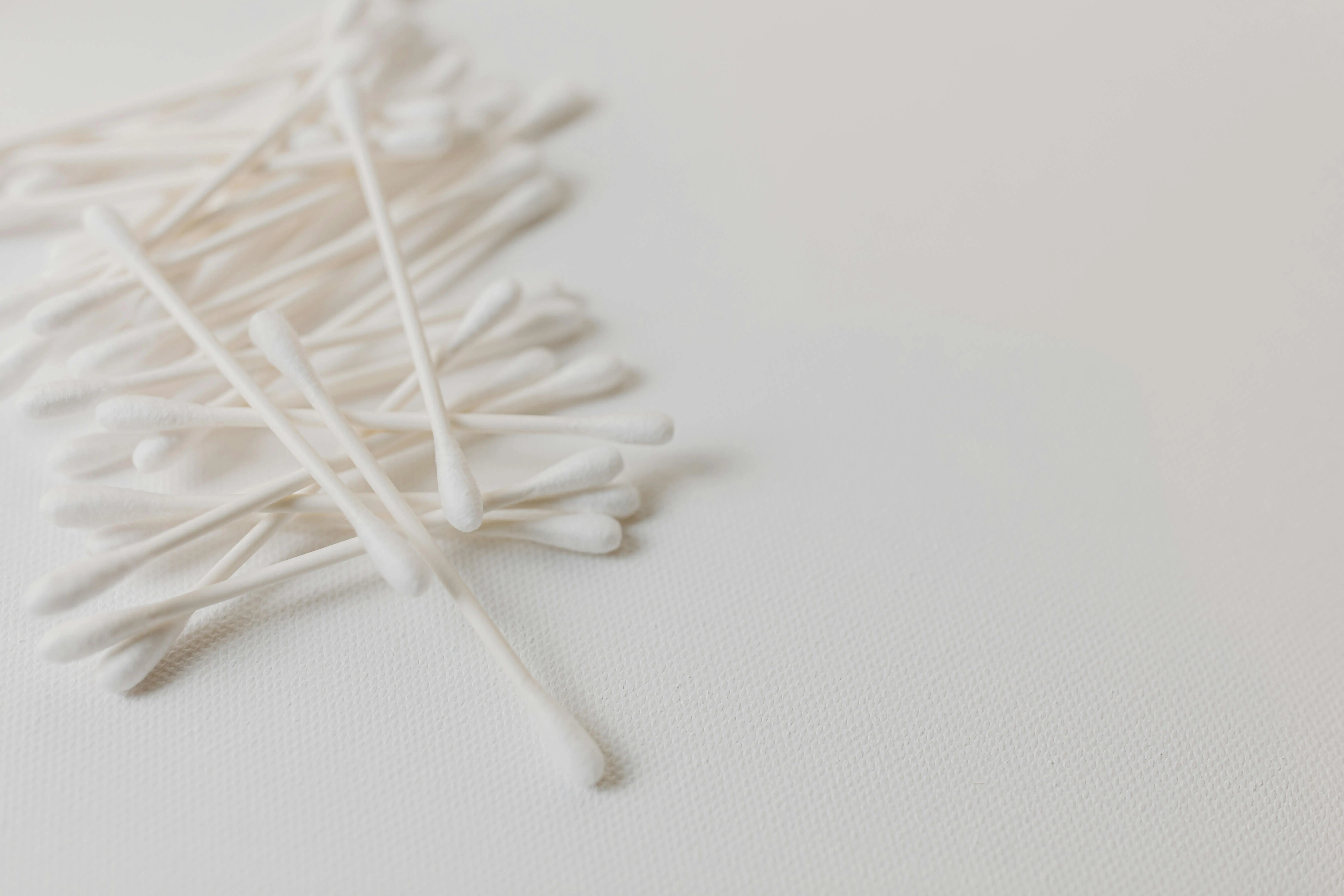 how to wash 100 cotton Minimalist close-up of white cotton swabs on a clean white background, emphasizing hygiene.