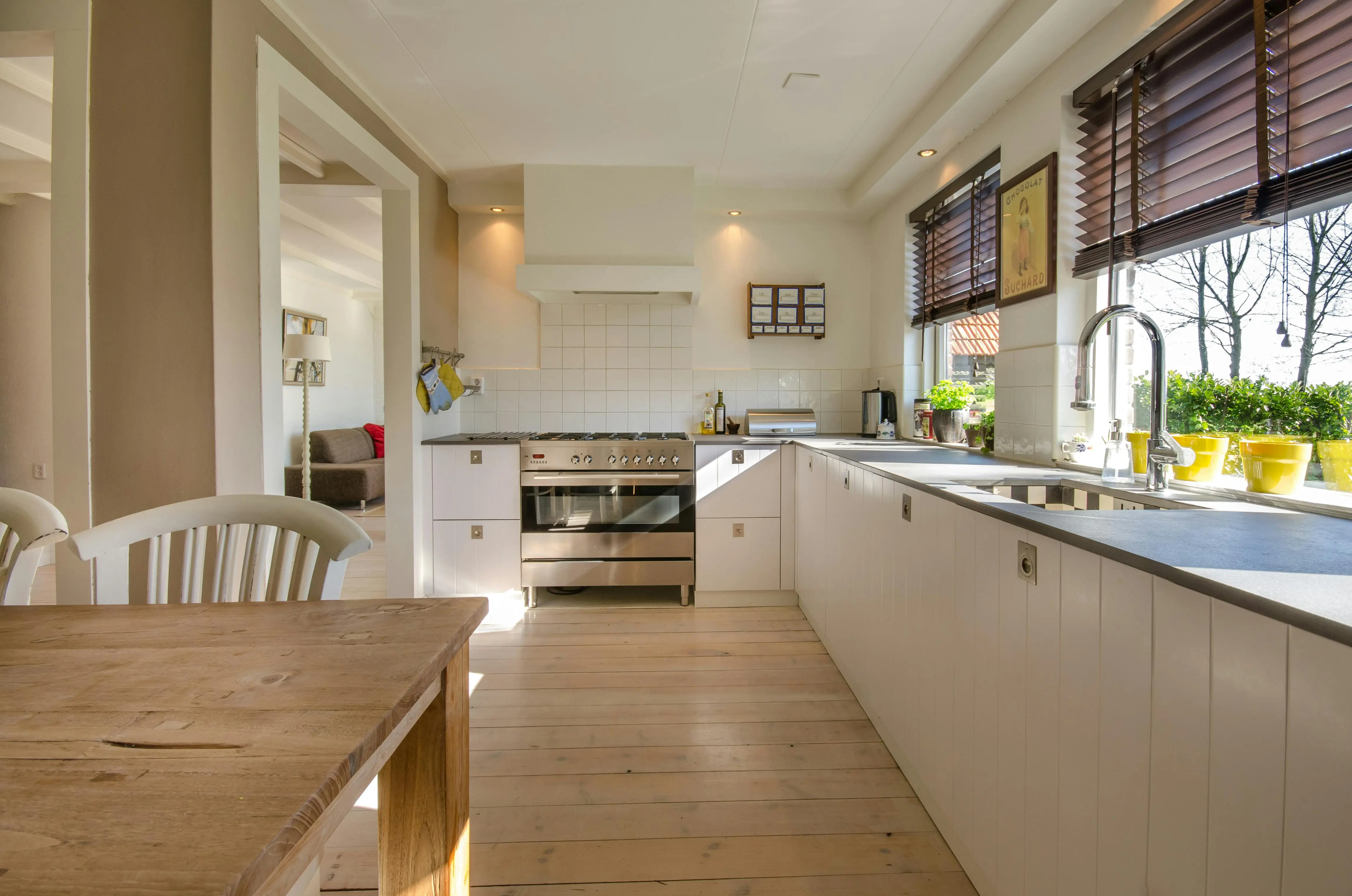 oak cabinets white Bright kitchen interior featuring wooden flooring, sleek cabinets, and natural sunlight.