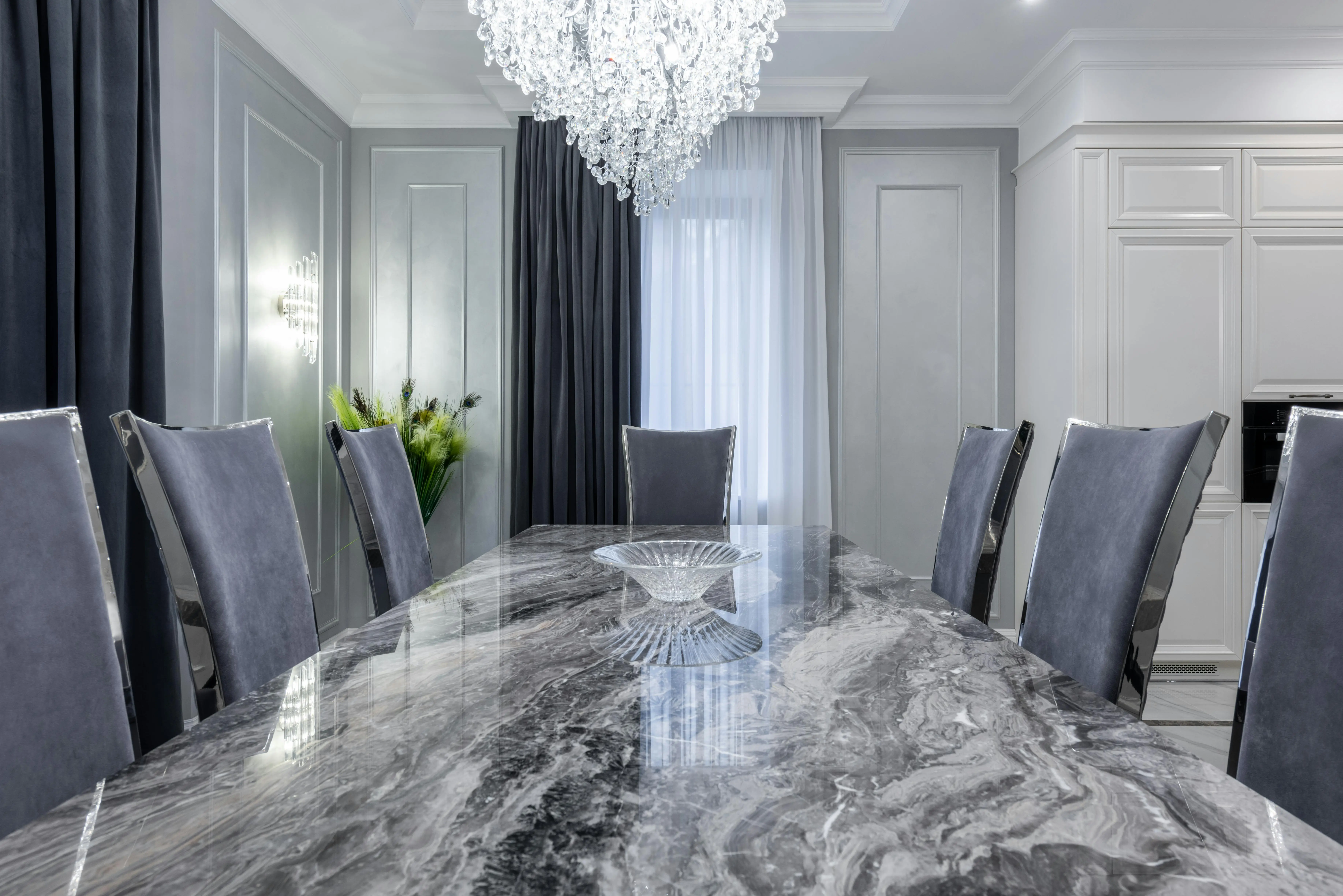 coastal chandelier Interior of contemporary dining room with stylish marble table and comfortable chairs in light apartment in daytime