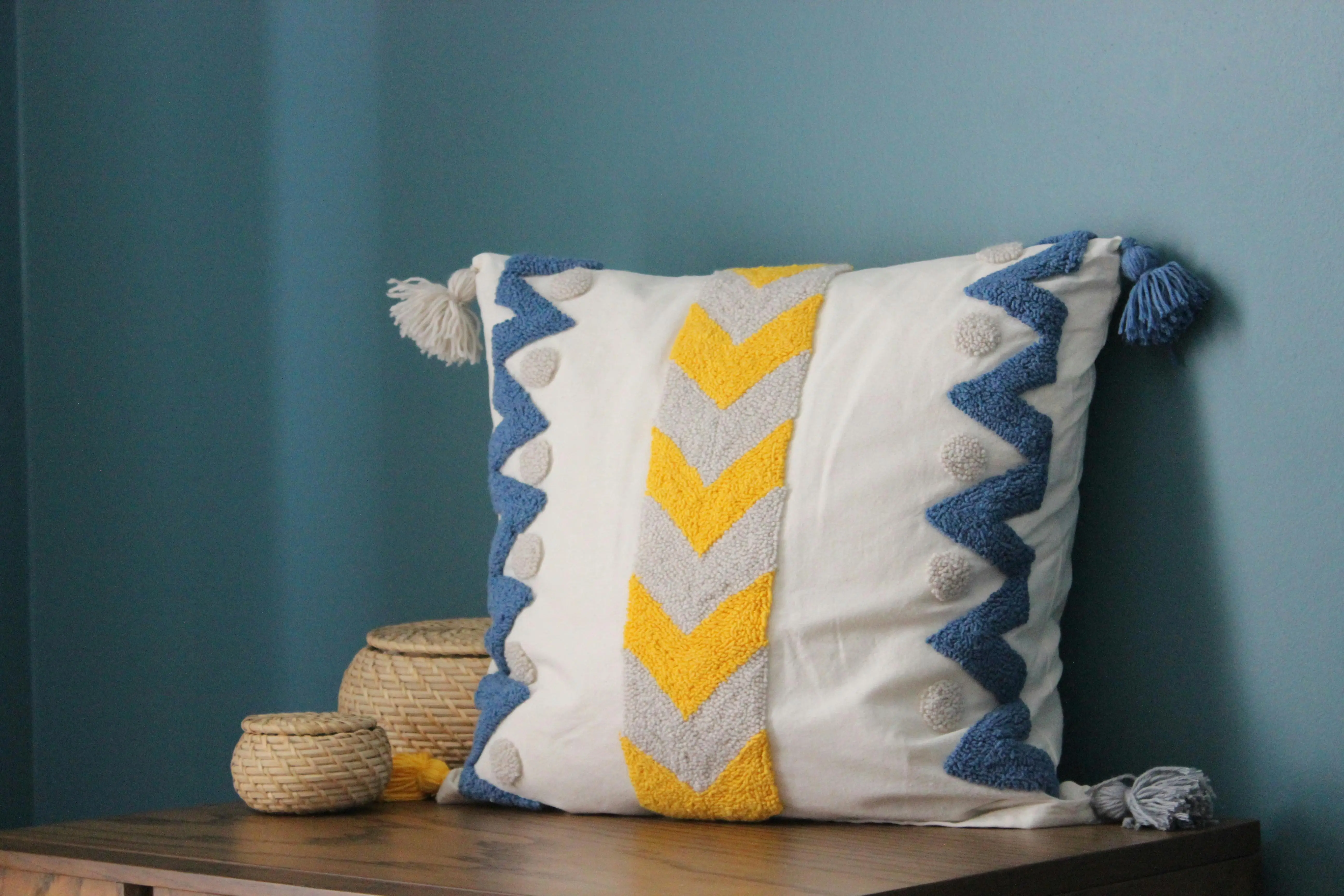 blue and white pillows A modern throw pillow with chevron pattern and tassels, perfect for cozy interiors.