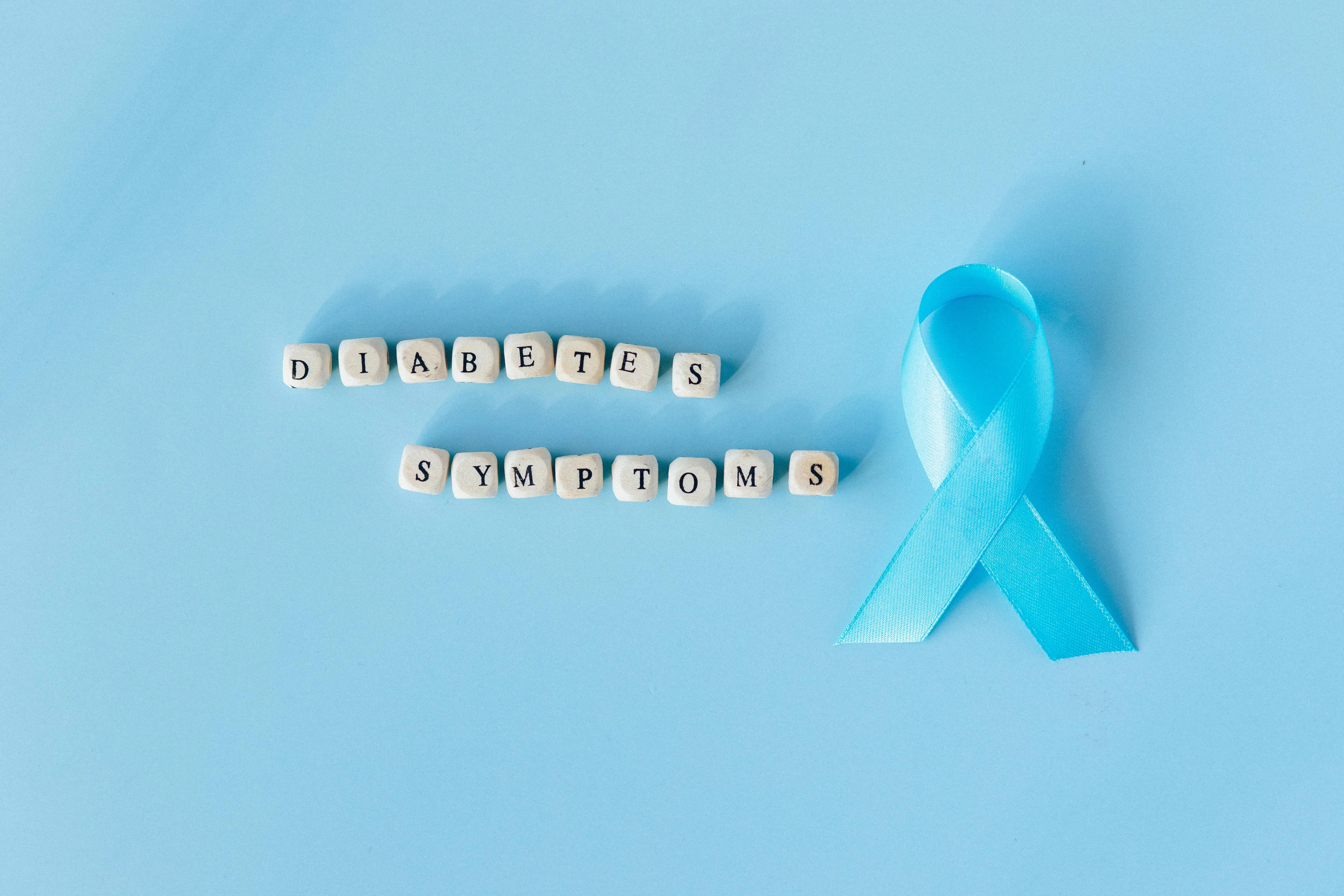 flat roof coating Conceptual image emphasizing diabetes symptoms with a blue awareness ribbon and letter dice.