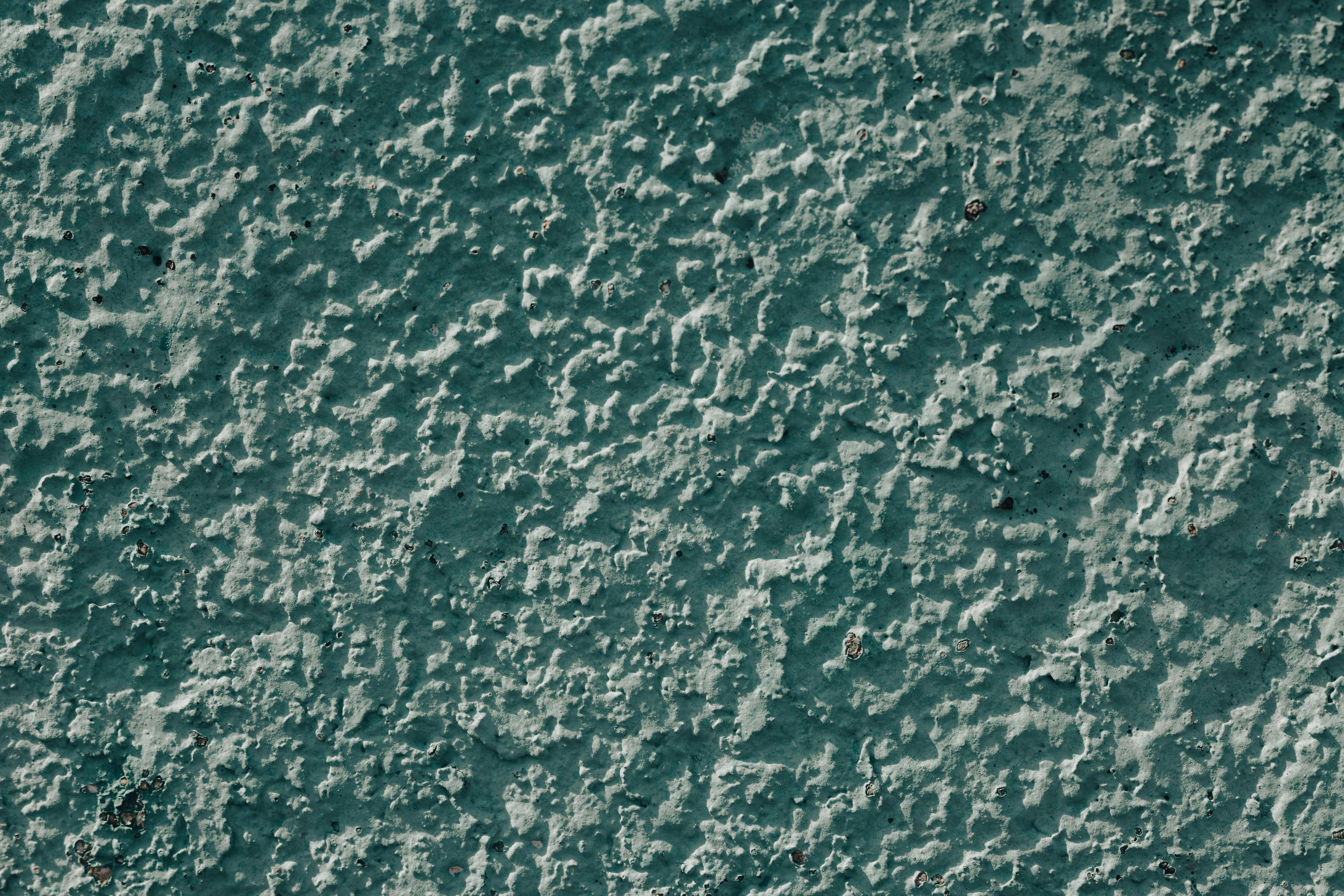 what to put around foundation of house Close-up of a rough textured blue wall surface, showcasing an intricate pattern.