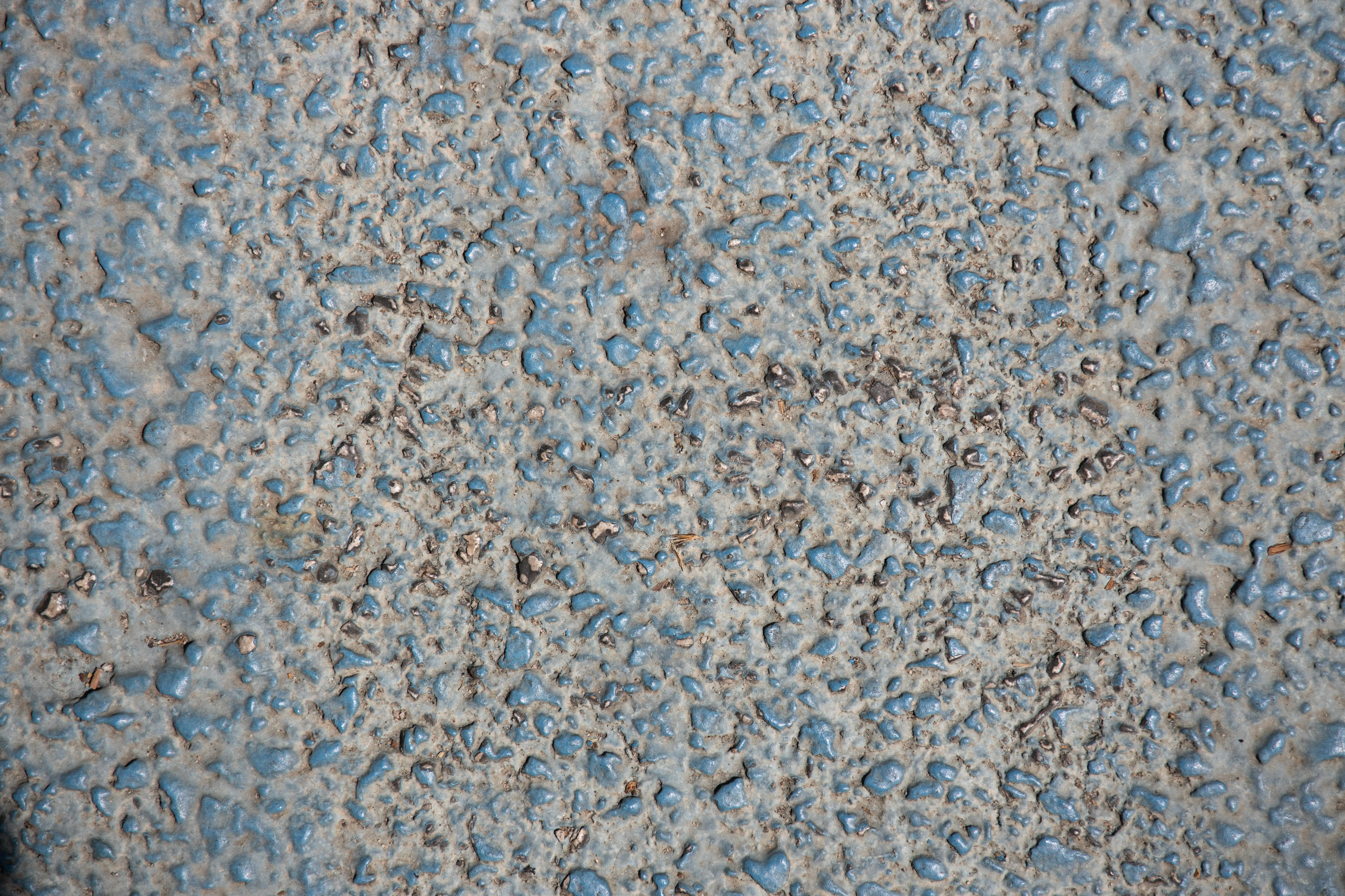 grey granite countertops Close-up of a textured granite surface, showcasing roughness with visible pebbles for background use.