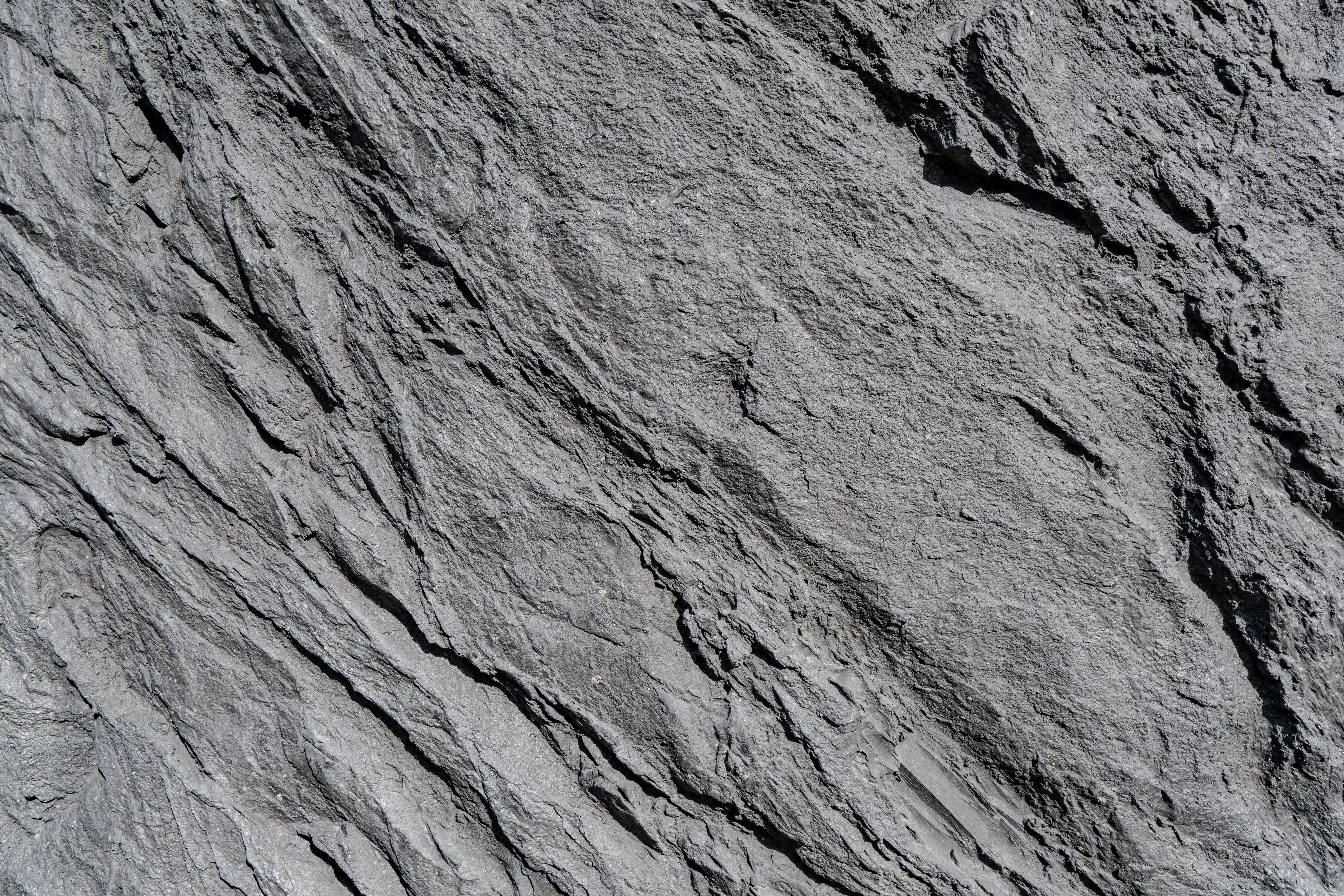 grey granite countertops Detailed image of a rough rock surface showcasing natural geology and texture.