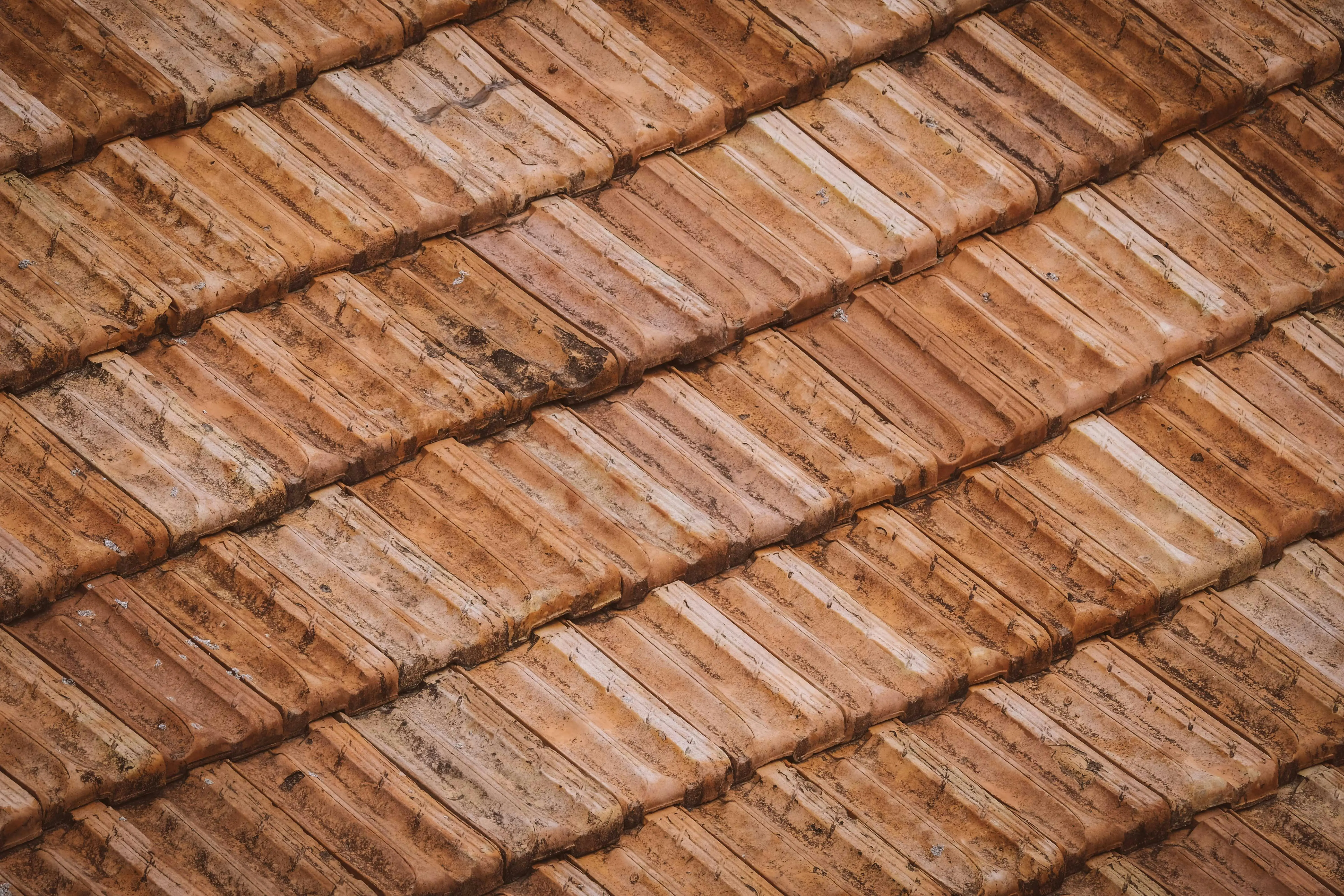 brown tiles From above of grunge weathered textured surface of roof tiles of aged building
