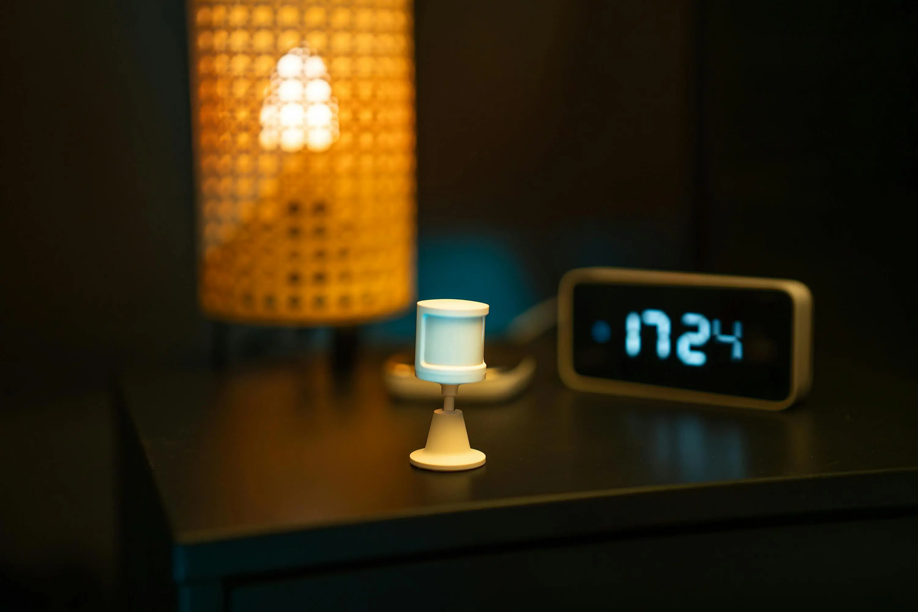 battery powered motion sensor spotlight A smart home nightstand featuring a motion sensor, digital clock, and warm-toned lamp, creating a cozy ambiance.