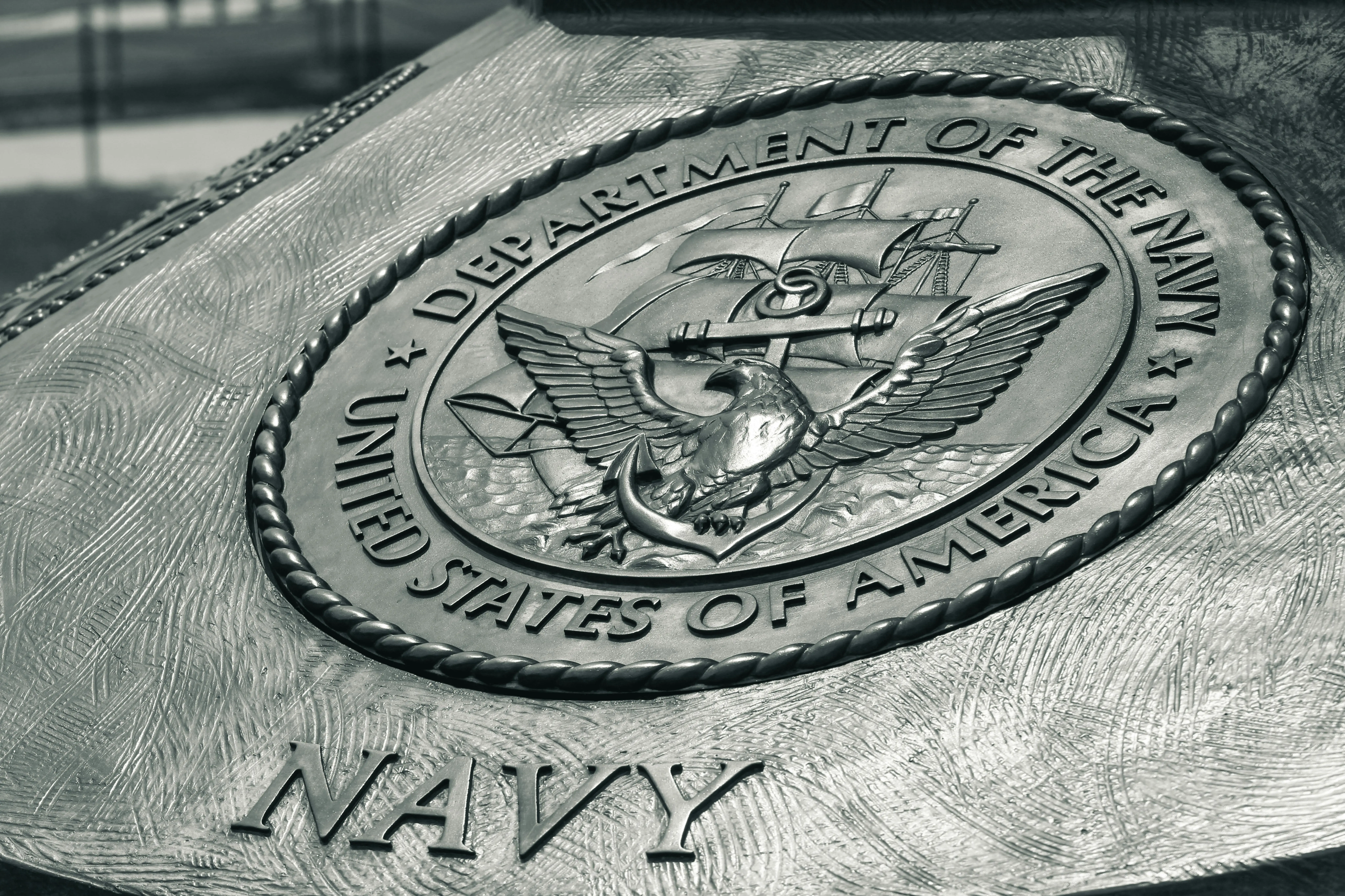 navy throw pillows Detailed view of the United States Navy emblem on a monument in Washington D.C., showcasing naval heritage.