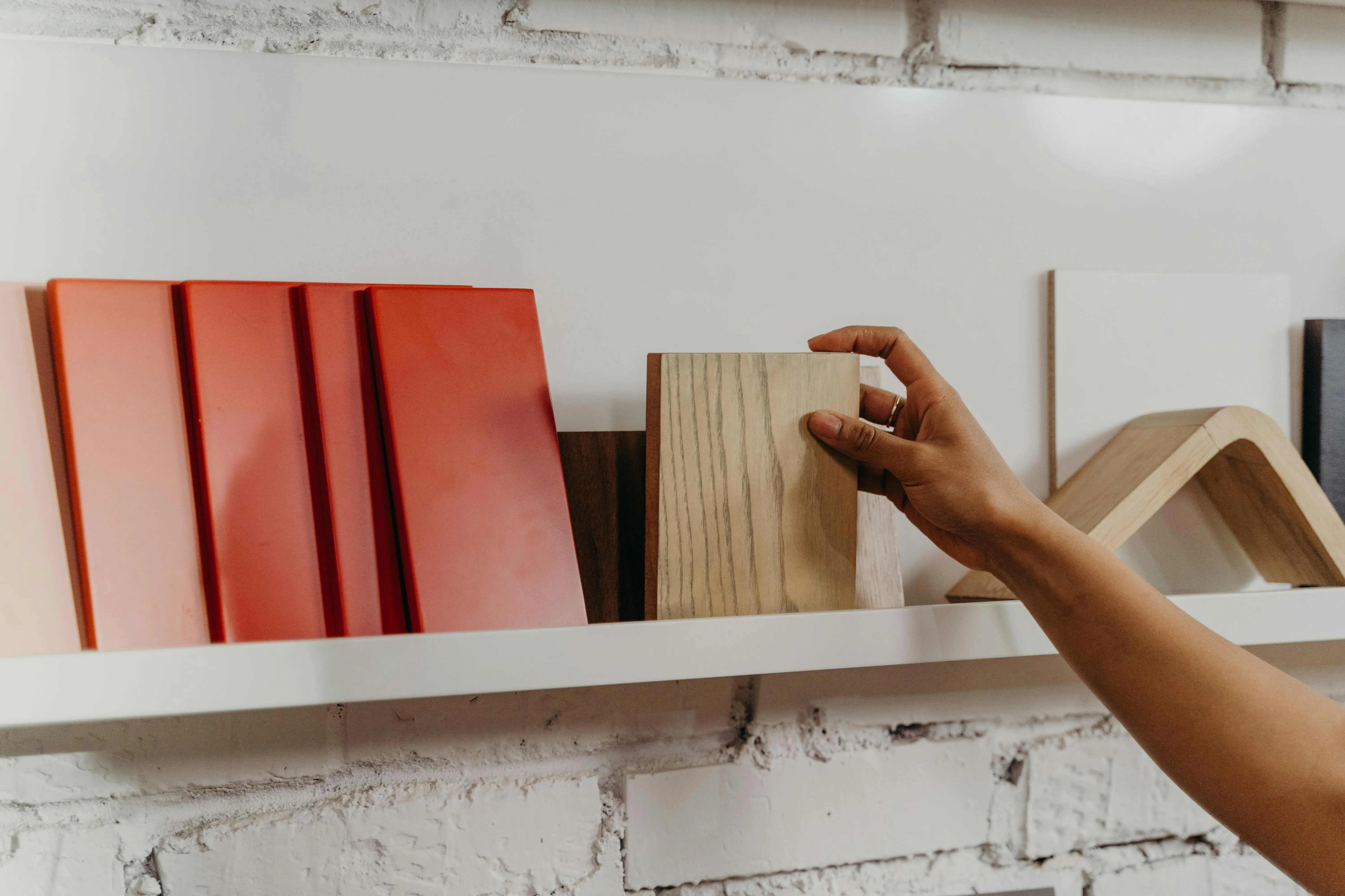 dark blue siding colors A hand selecting a wooden sample from a display shelf featuring various construction materials.